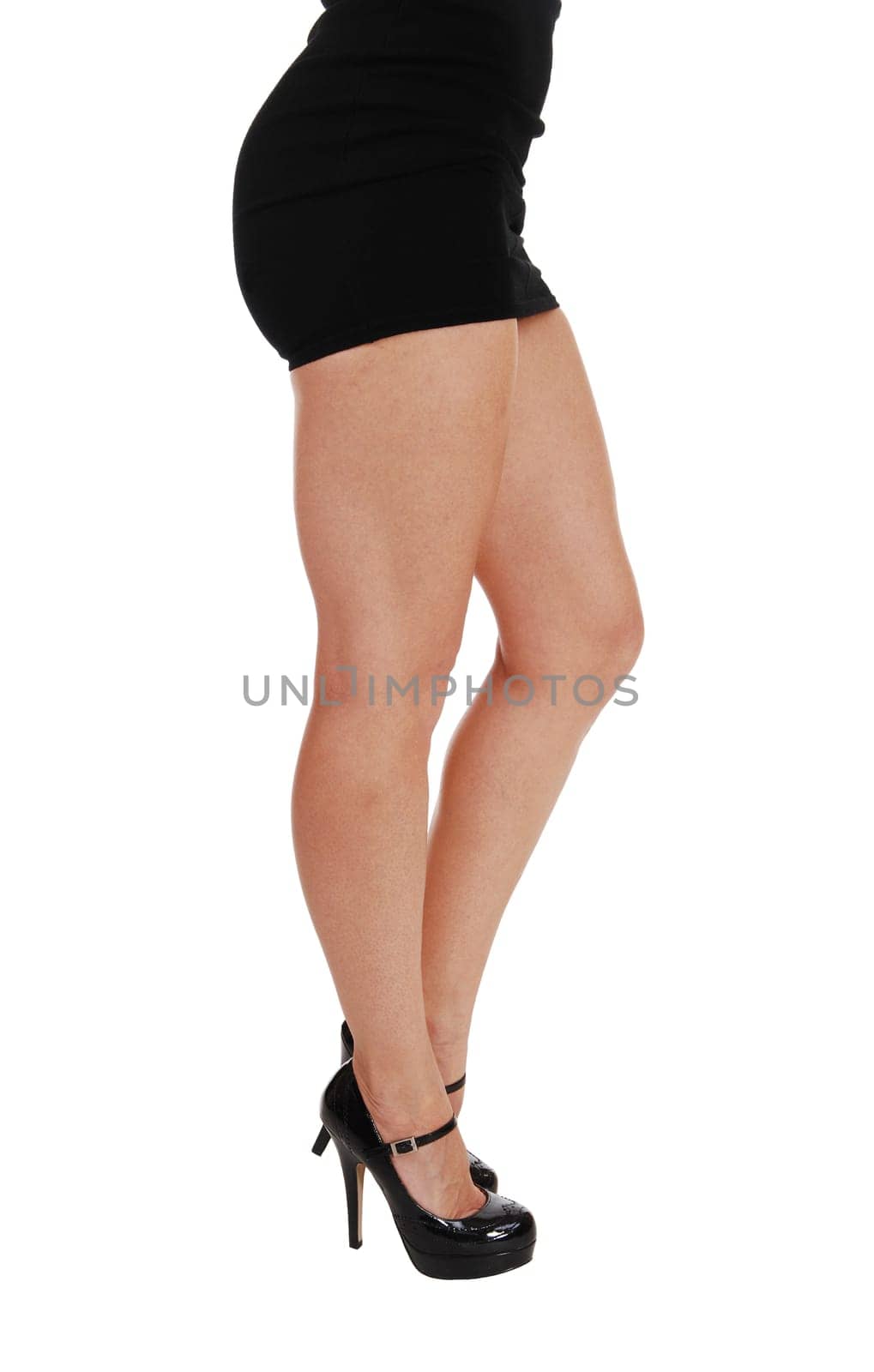 The bottom part a slim young woman with long legs and a black dress.standing isolated on white background..