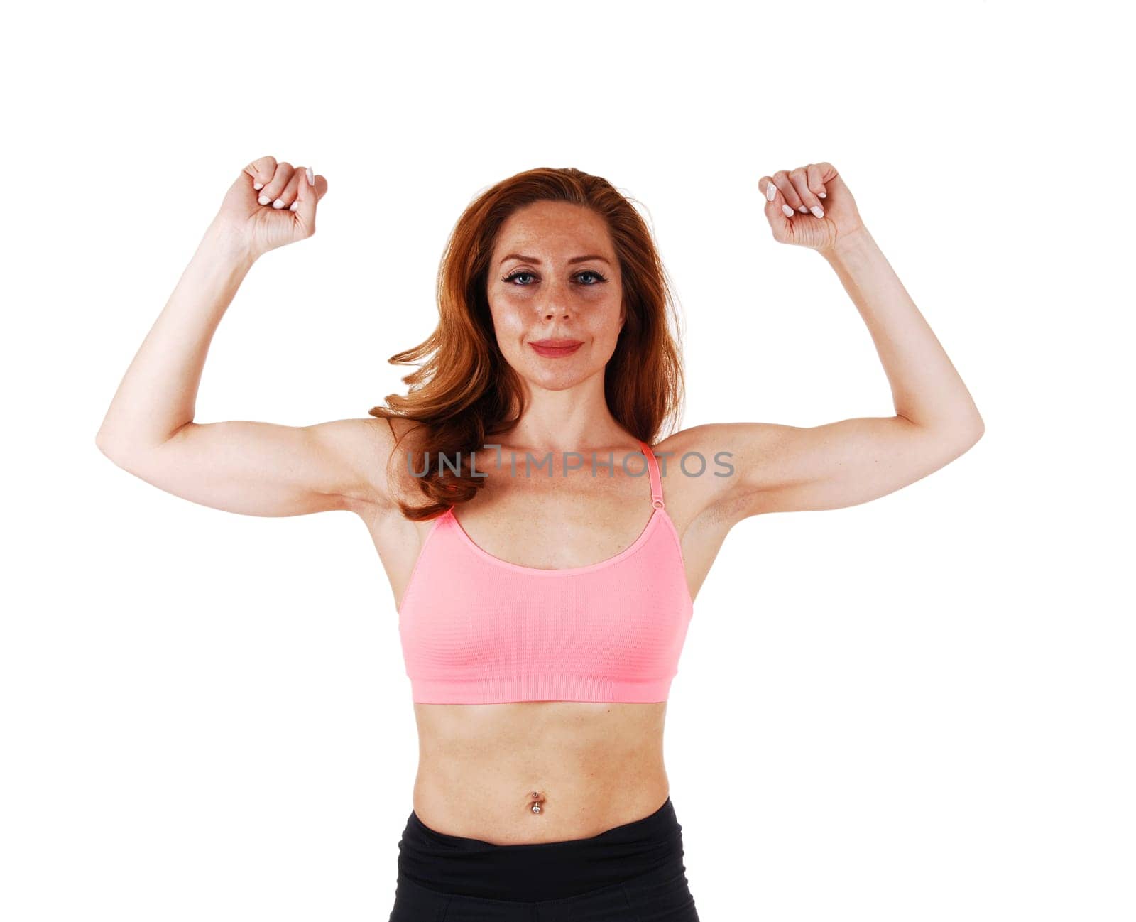 A young brunette woman in a portrait picture in a pink sports bra, showing.her muscles, isolated on white background..
