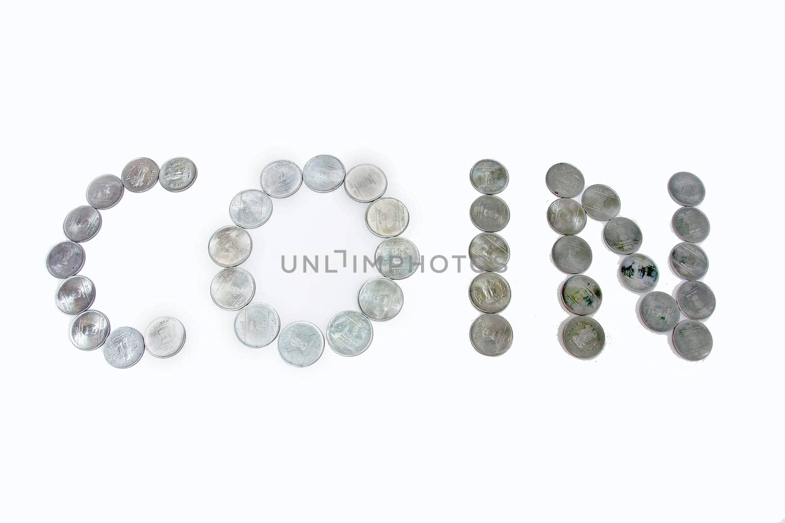 Arrangement of metallic coins to make the word COIN, isolated on white