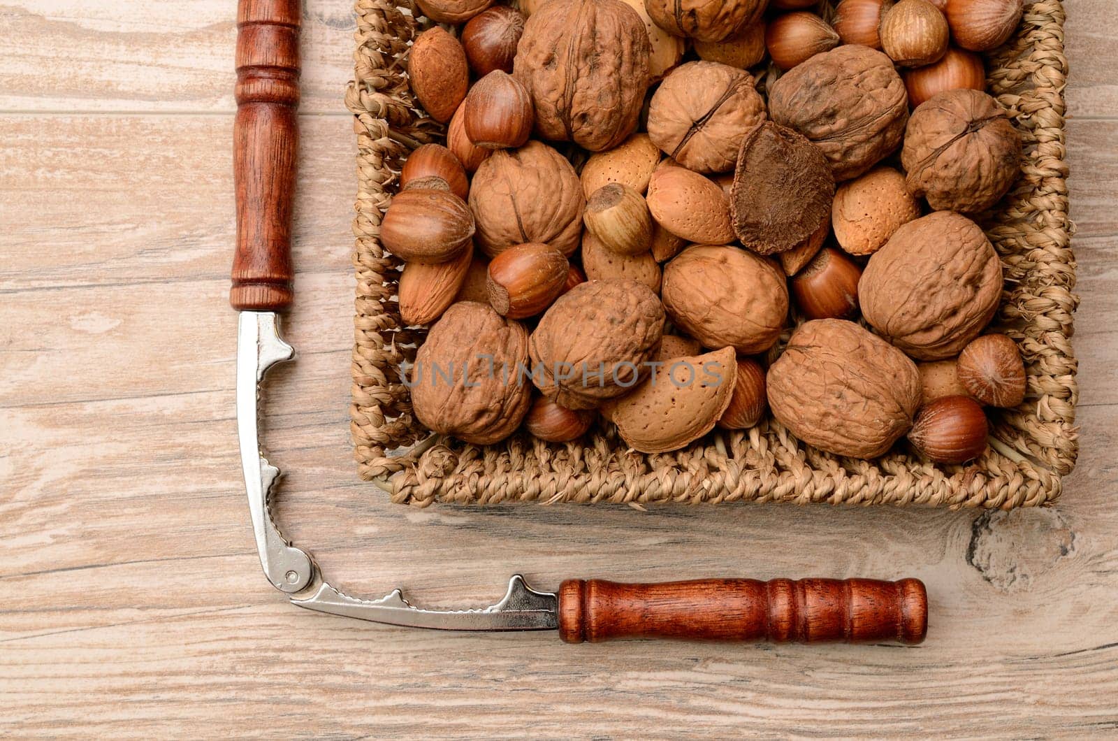 Nuts mix in a basket with a nutcracker