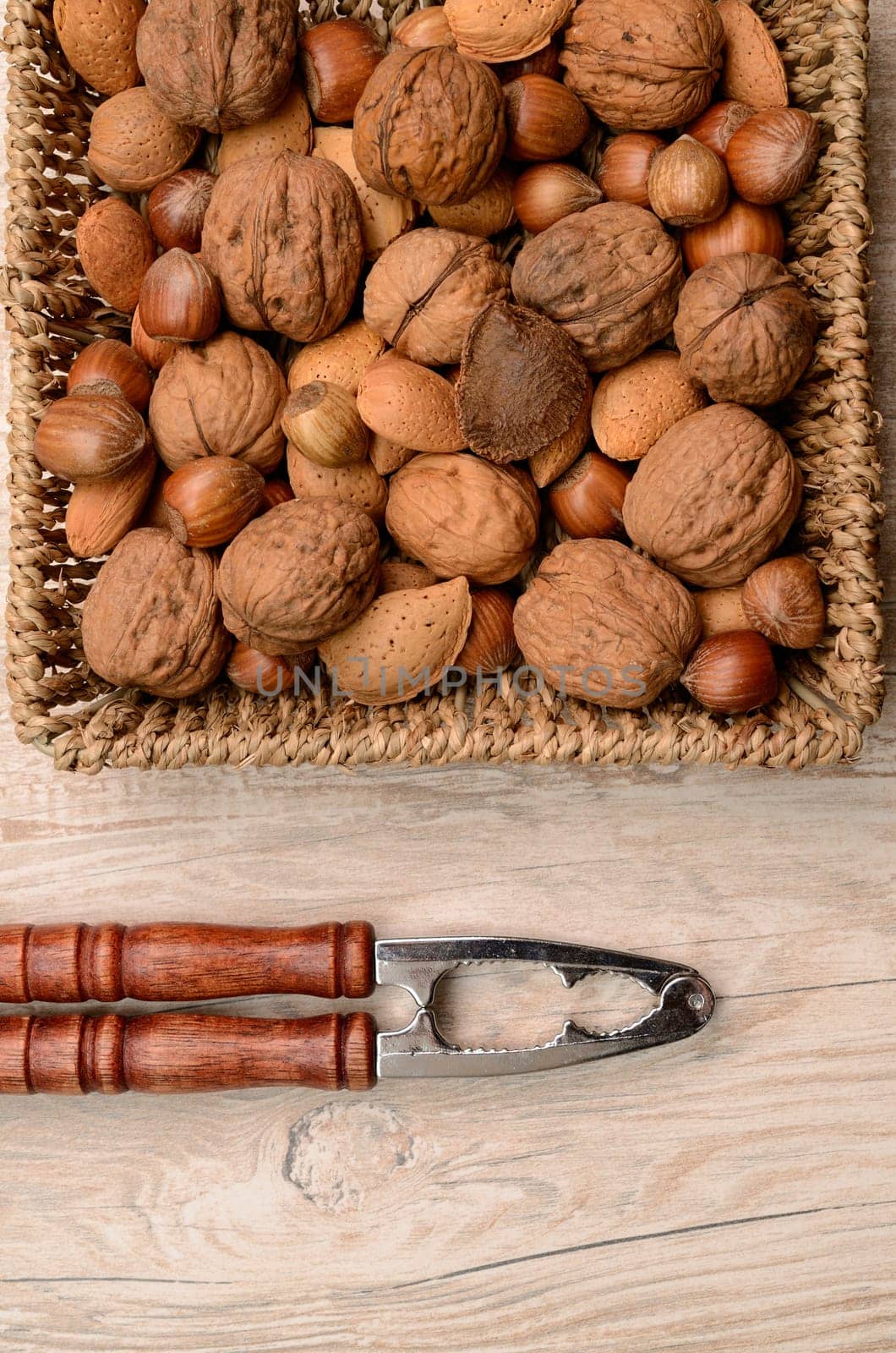 Nuts mix in a basket with a nutcracker