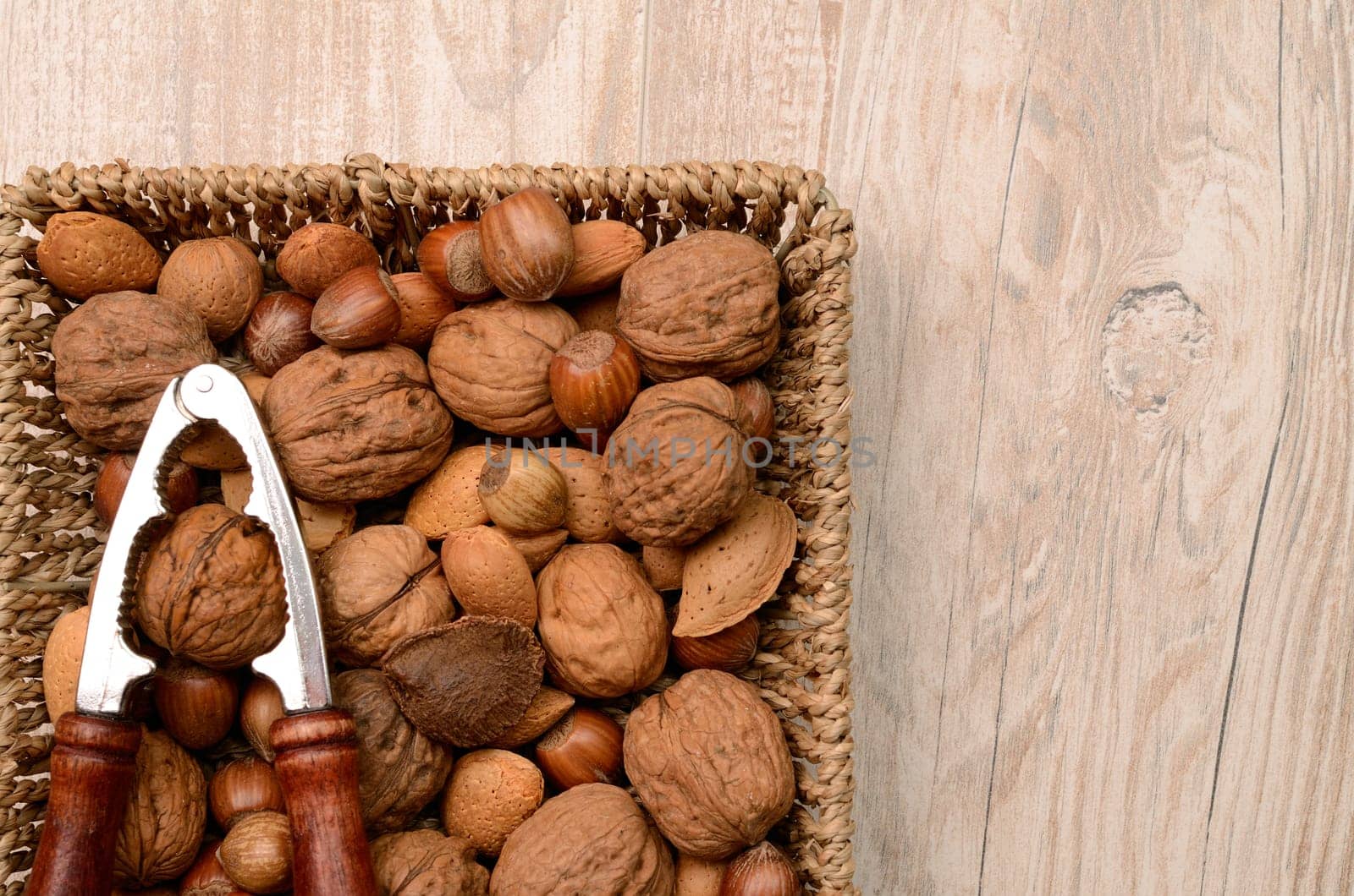 Nuts mix in a basket with a nutcracker