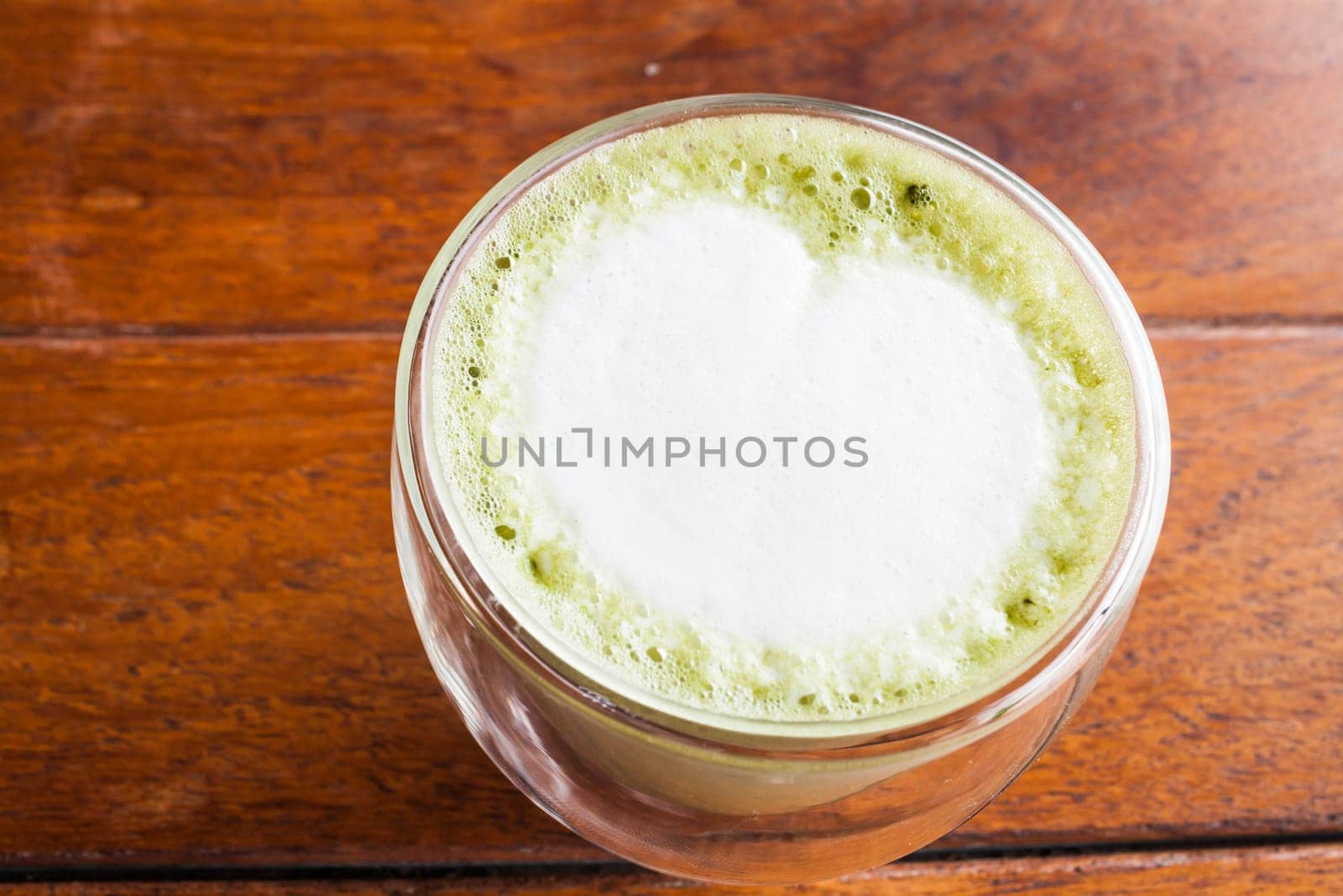 Hot matcha green tea latte on wooden table