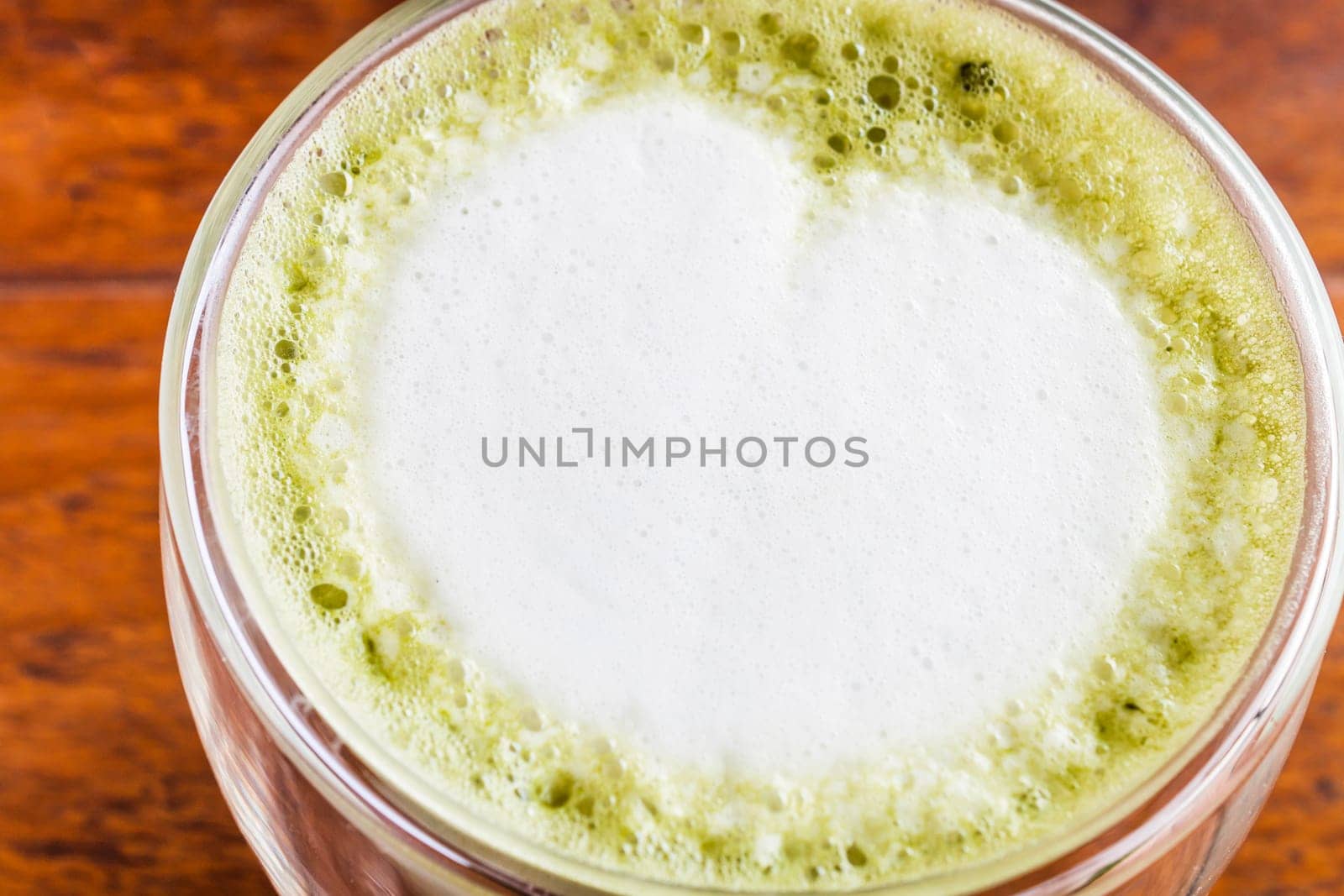 Close up hot matcha green tea latte on wood table