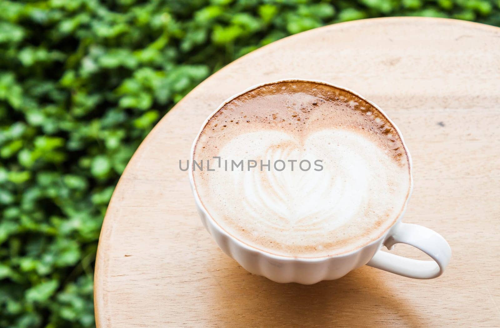 Free pour hot coffee latte serving on wood table