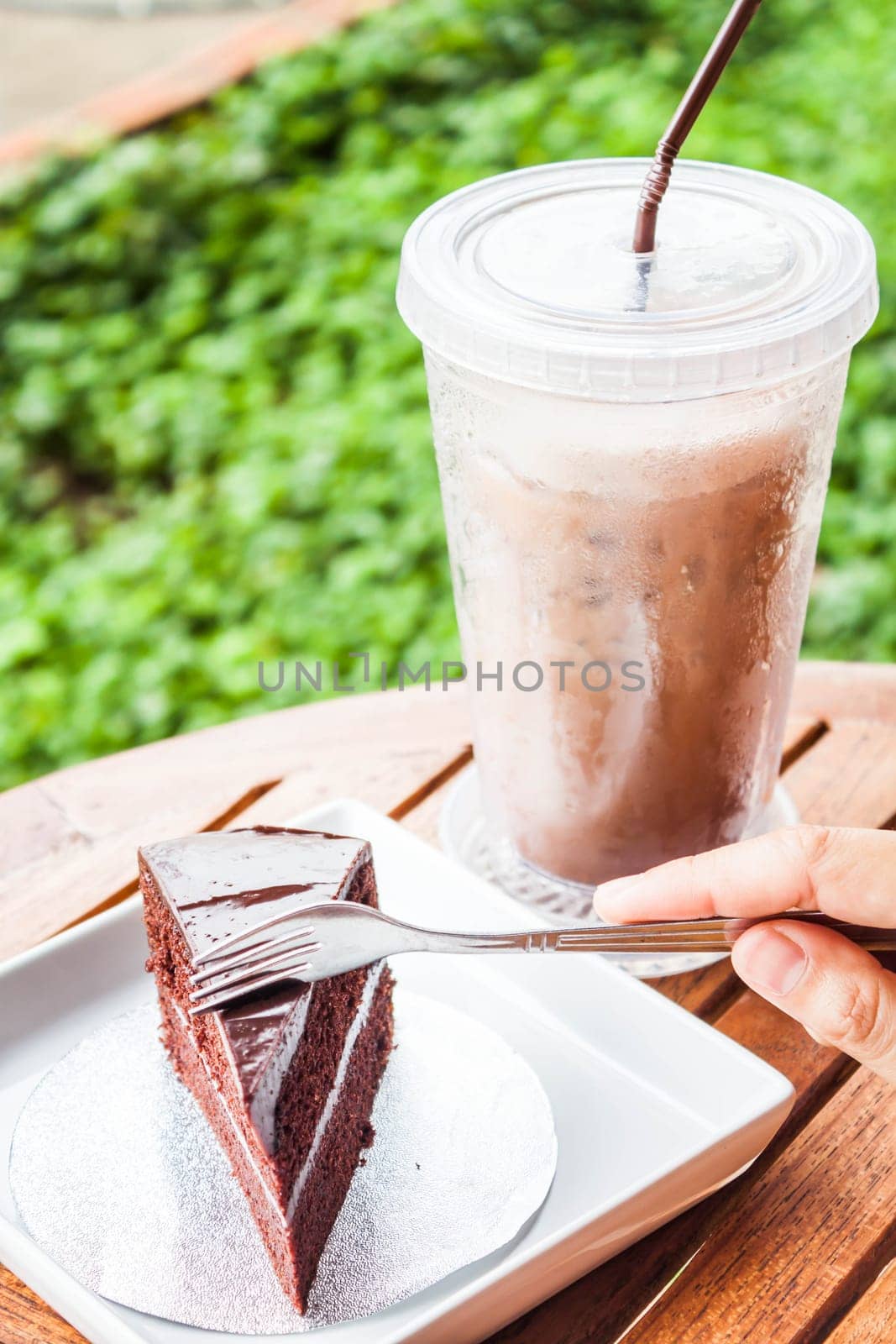 Custard chocolate cake and iced coffee serving on table