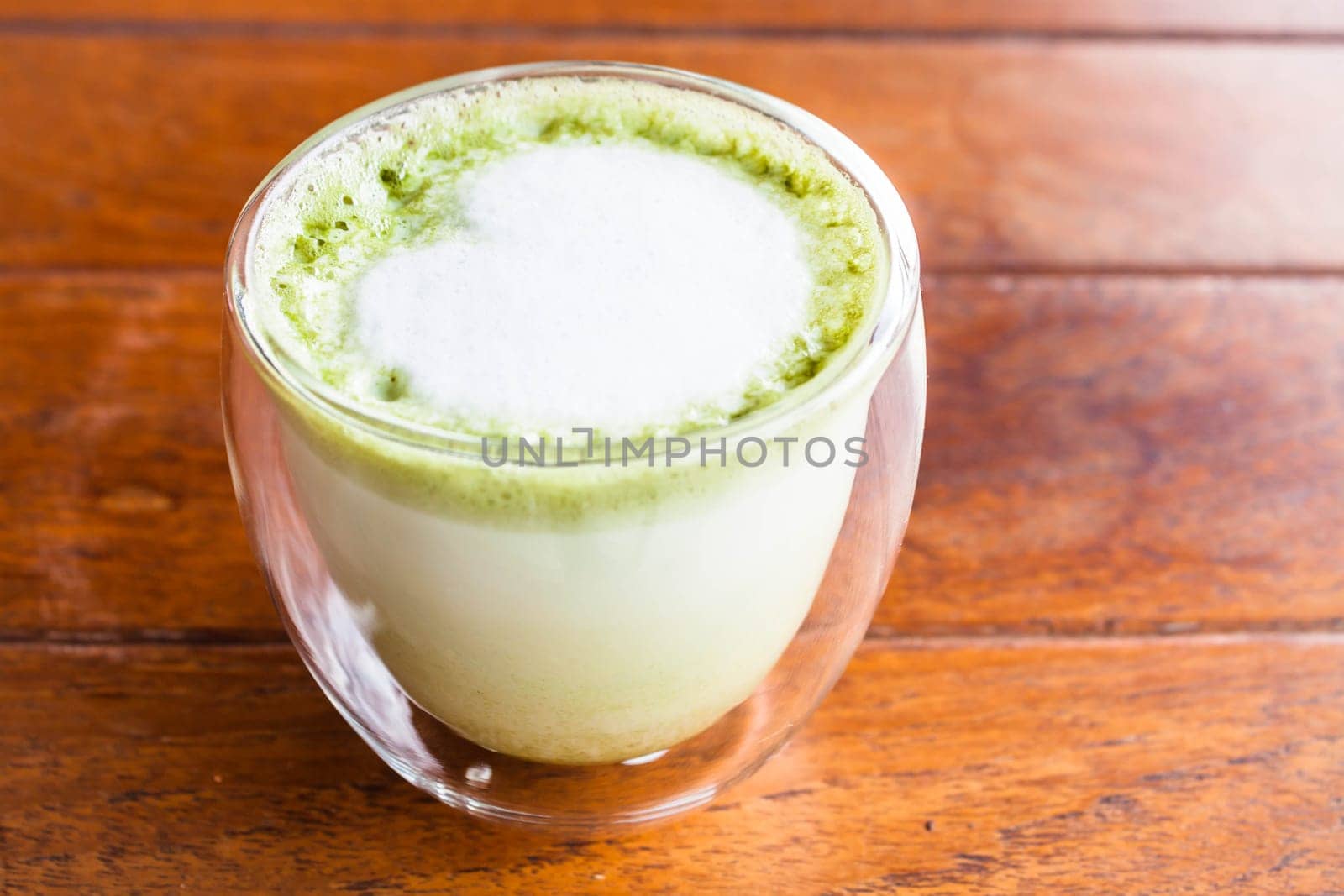 Glass of hot matcha green tea latte with milk microfoam
