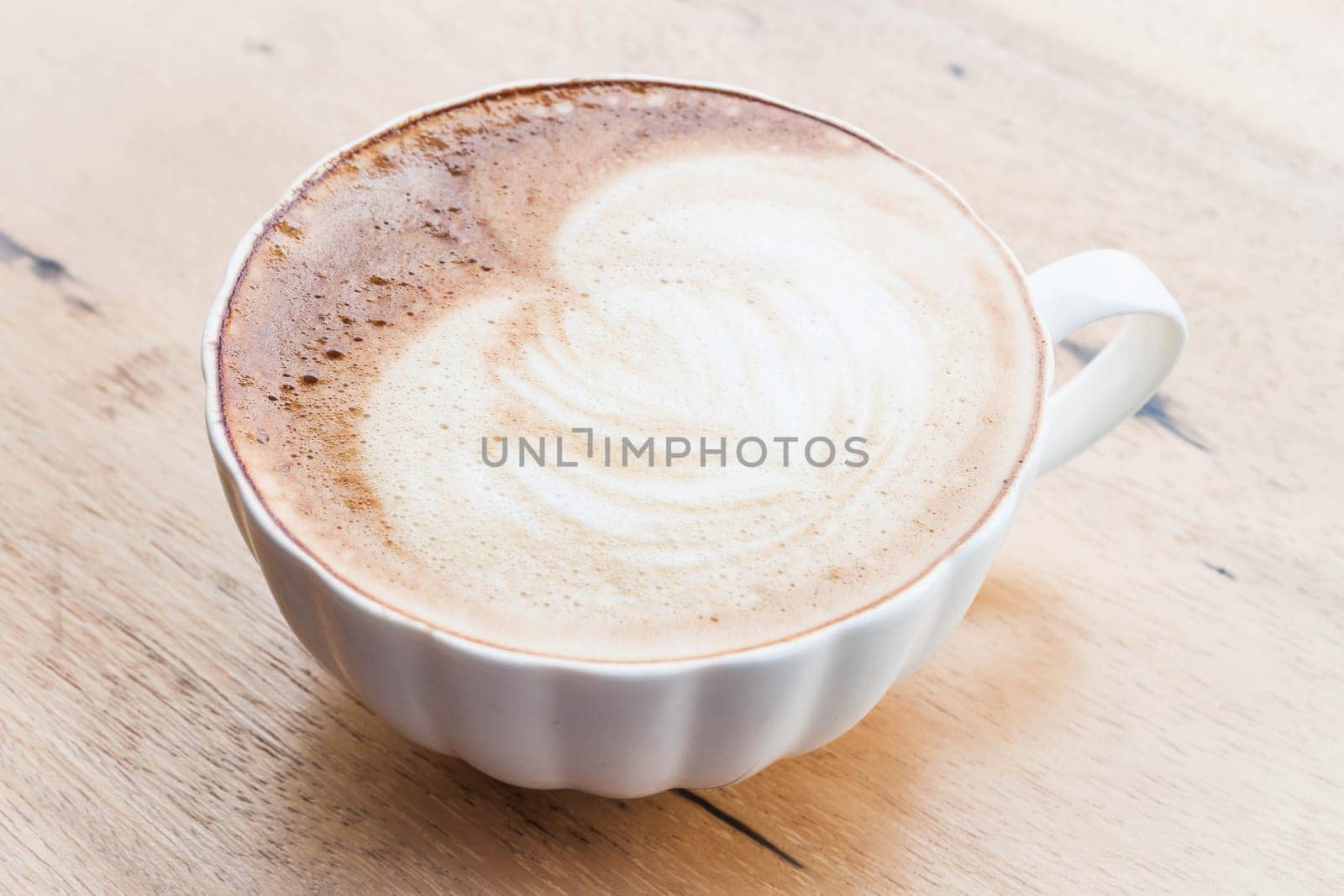 Free pour hot coffee latte art cup on wood background