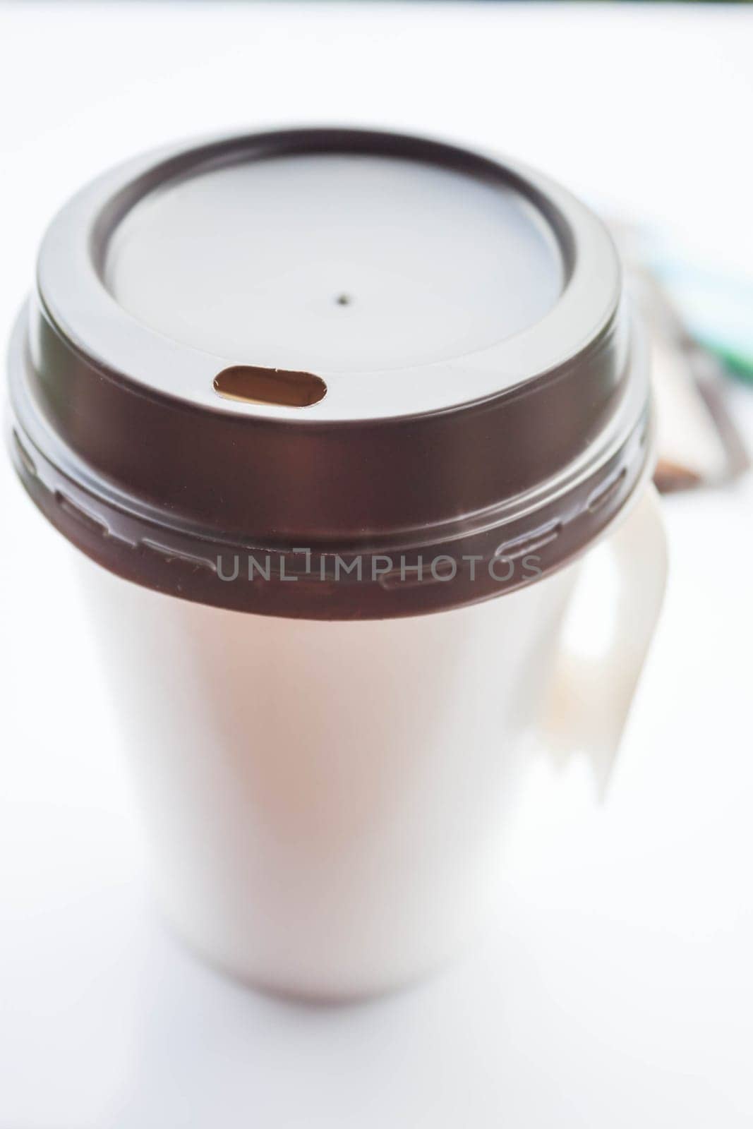Coffee in paper cup with sugar packs on white background