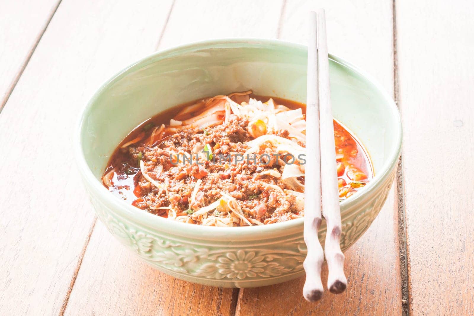 Bowl of spicy noodle soup with chopsticks