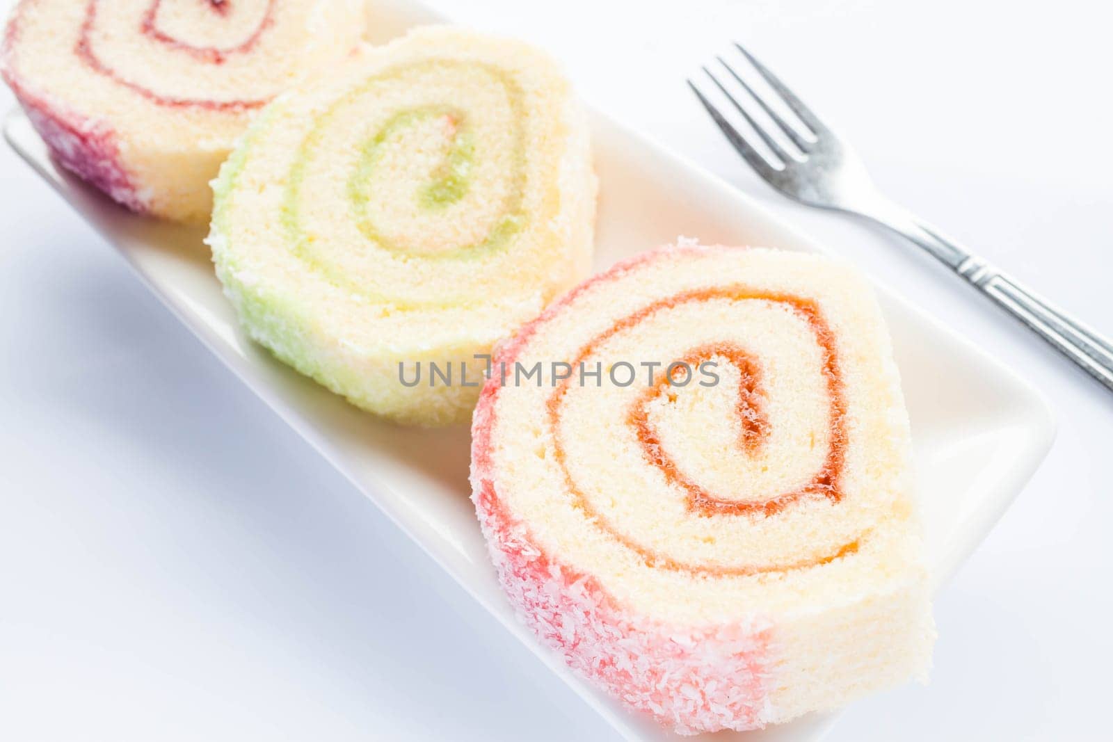 Set of colorful jam roll cakes with fork, stock photo