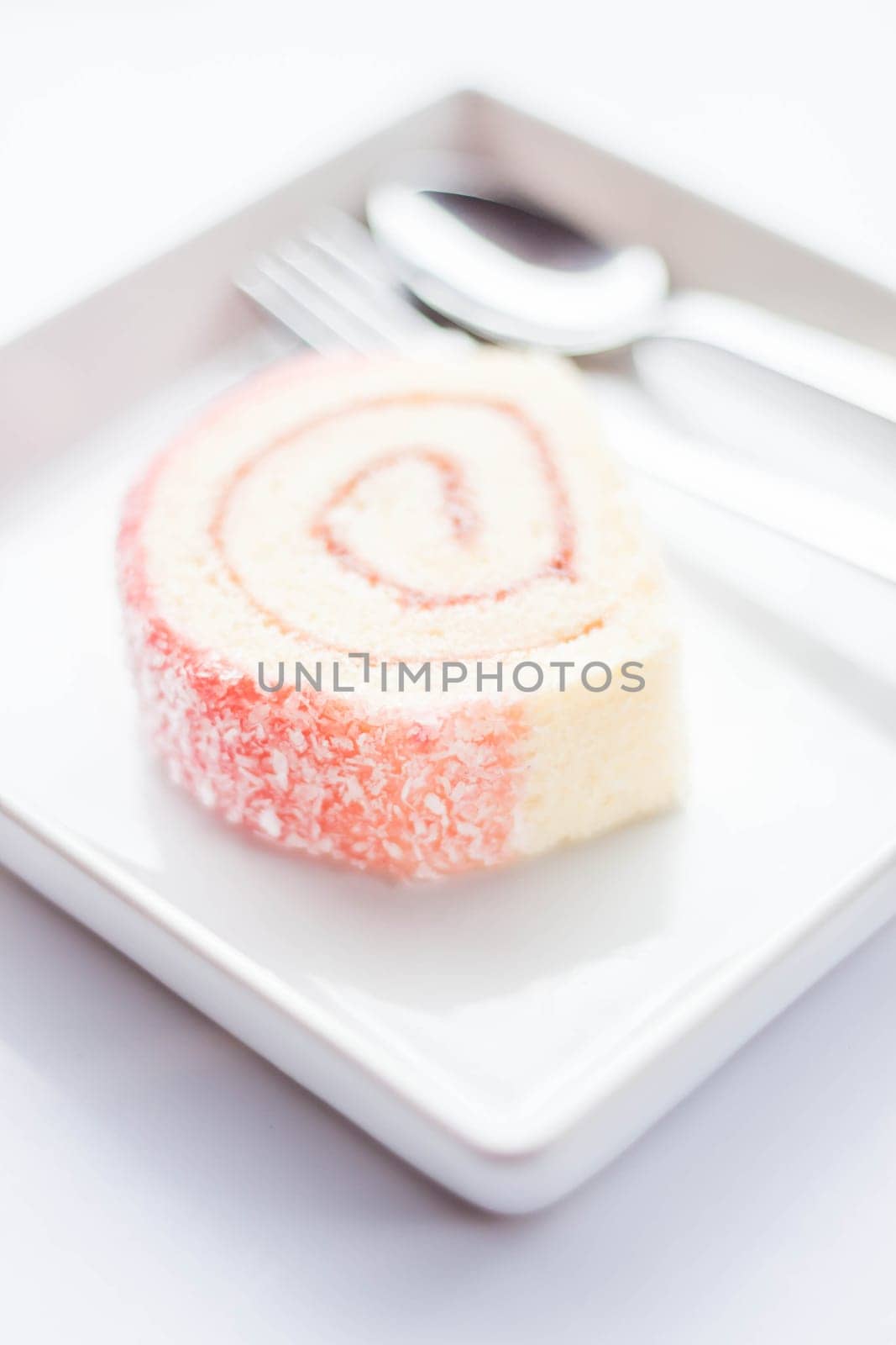 Sweet dish of pink jam roll cake, stock photo