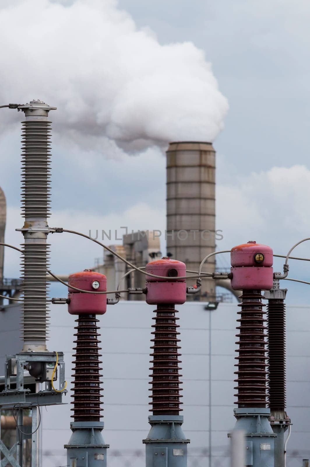 electrical insulators with the background of smoking chimney