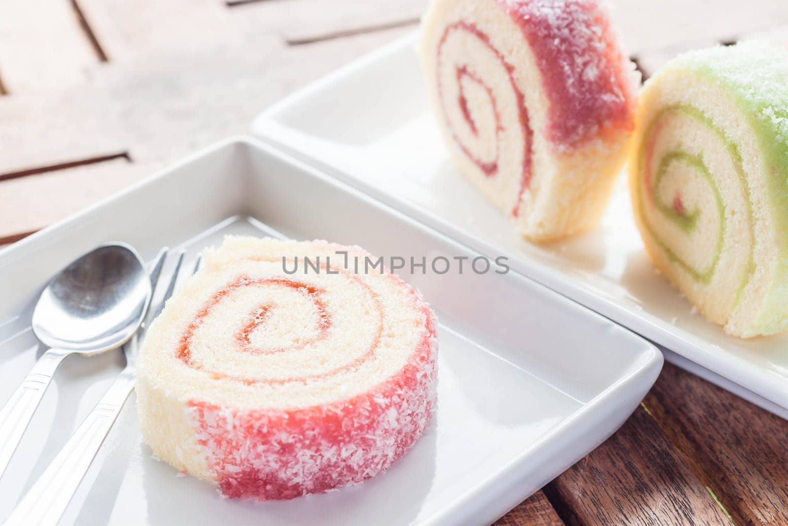 Set of colorful jam rolls with spoon and fork, stock photo