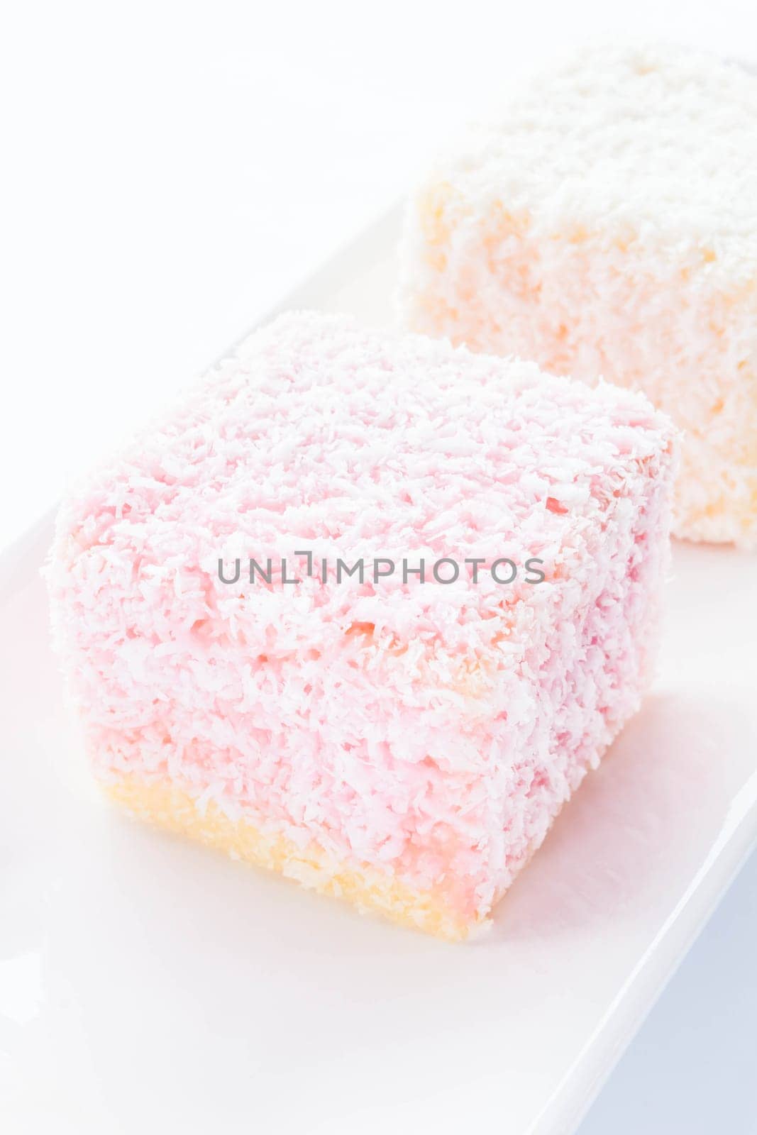 Lamington sponge cakes on white plate, stock photo