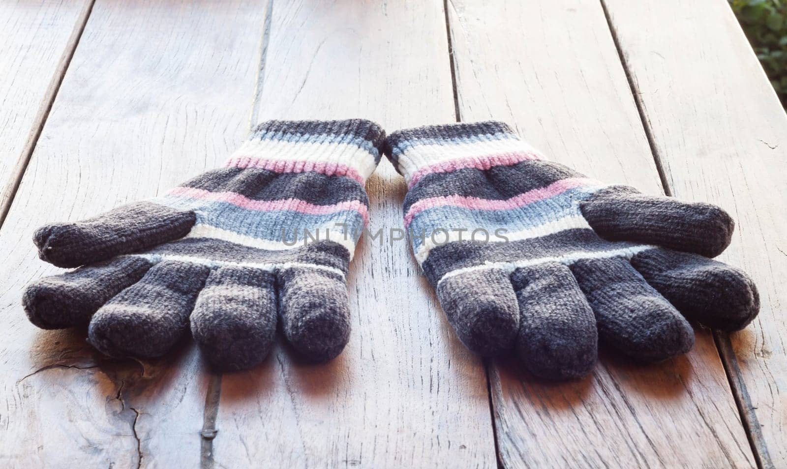 Knit winter gloves on wood table, stock photo
