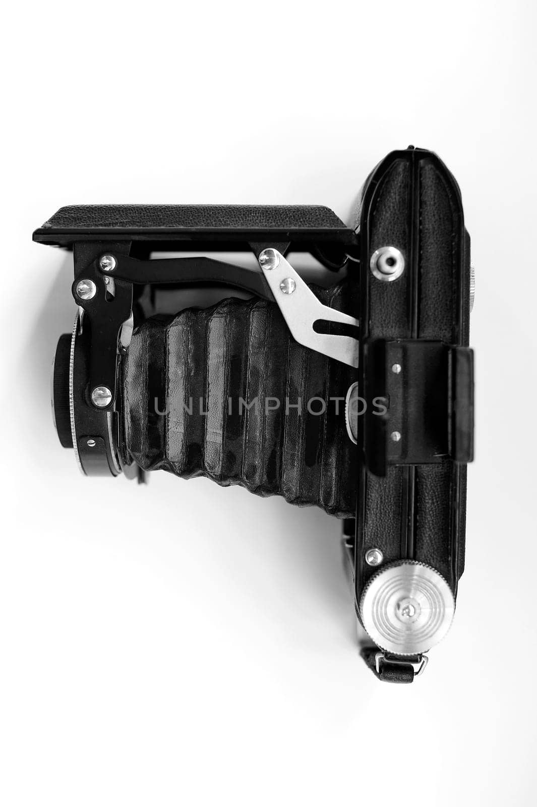 The photograph of an old folding camera against a white background.