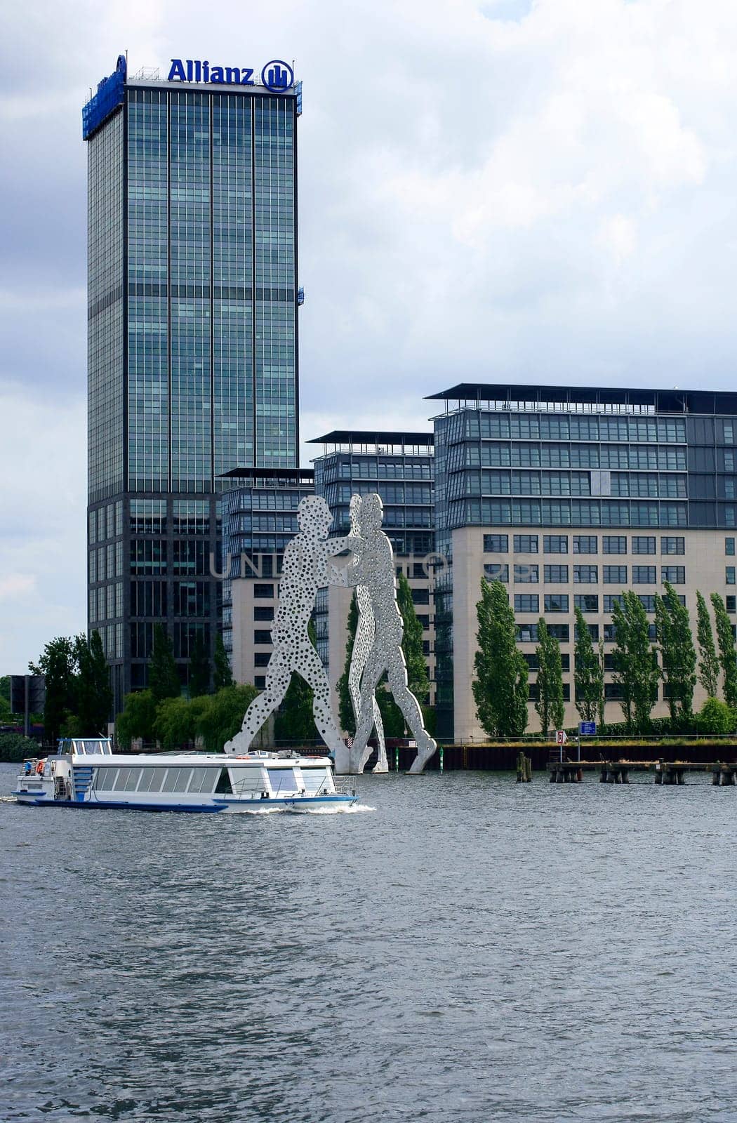 Berlin,Germany – June 16,2014: A passenger ship passes the artwork "Molecule man"" designed by Jonathan Borofsky on the River Spree on June 16,2014 in Berlin."
