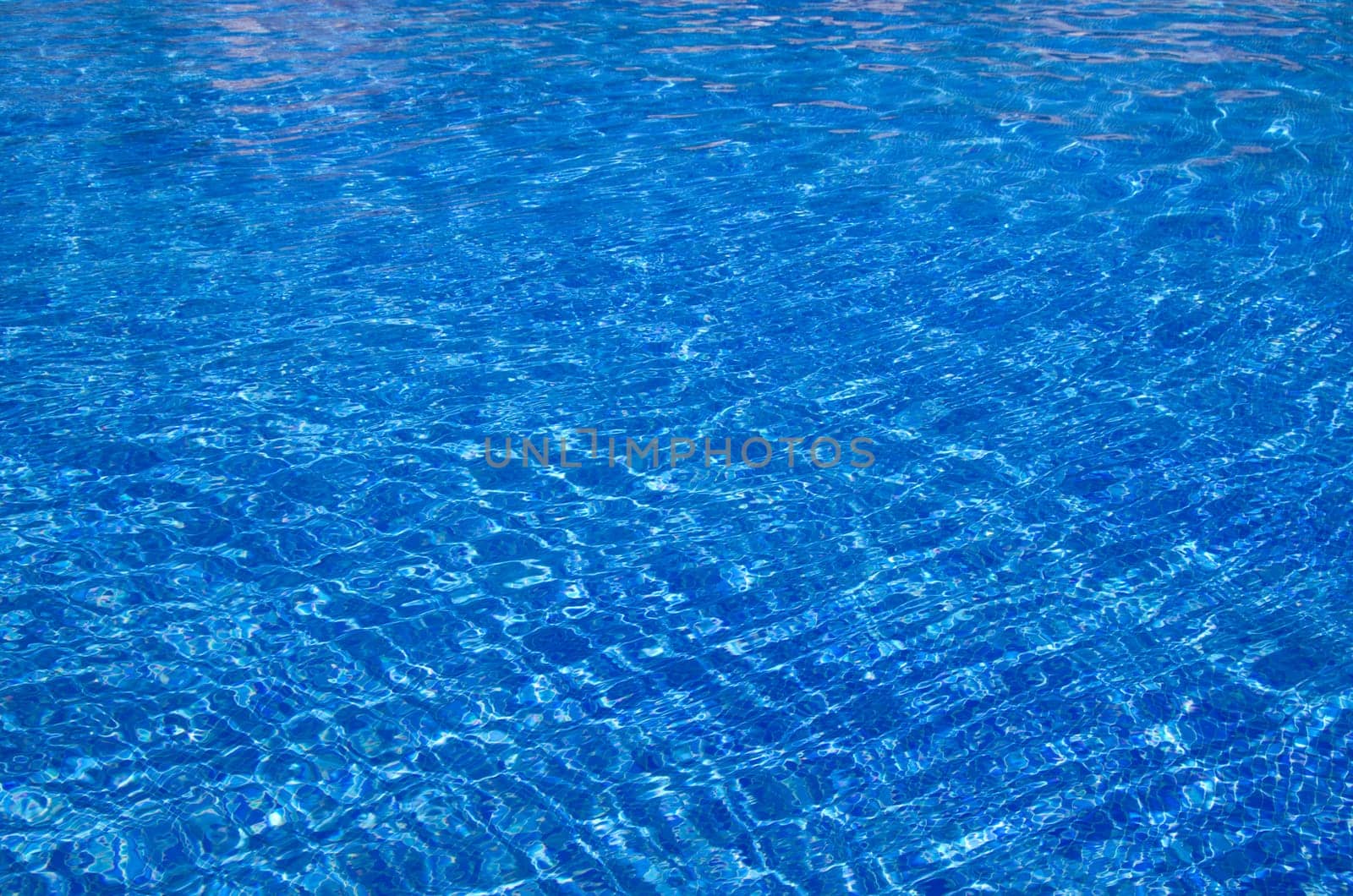Blue pool water with sun reflections