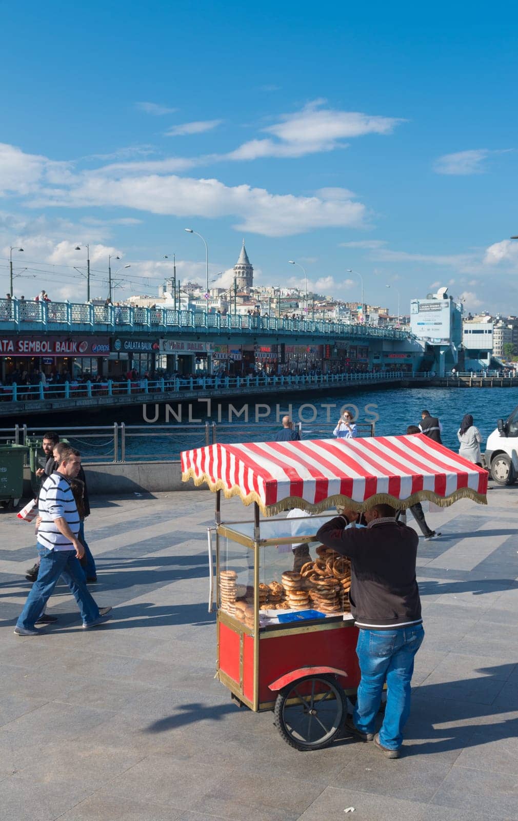 street vendor selling food in istanbul with the Galata bridge in the background. Eating on the street is part of local life here