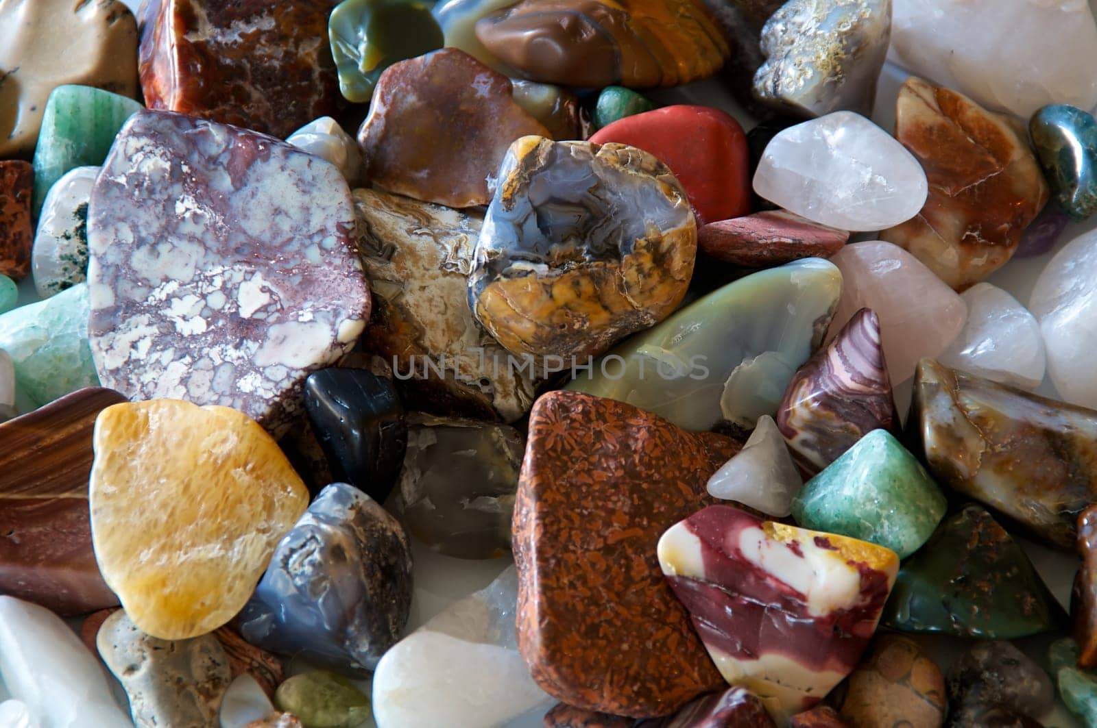 Close up of many different size, shape and colored tumbled stones