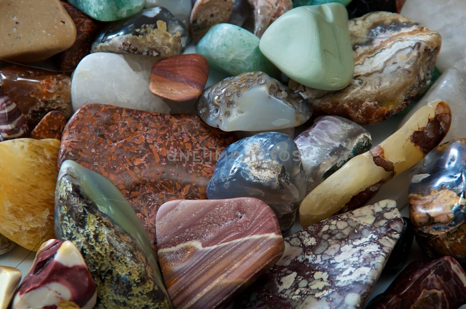 Close up of many different size, shape and colored tumbled stones