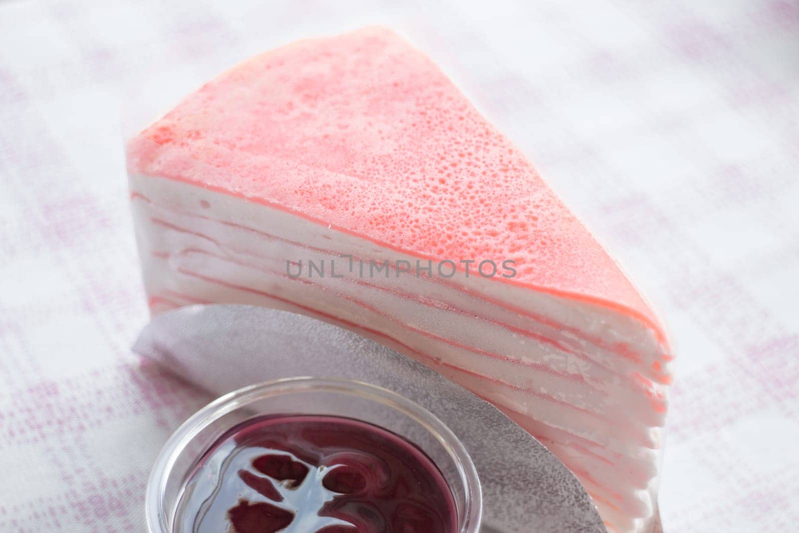 Close up pink crepe cake and blueberry sauce, stock photo