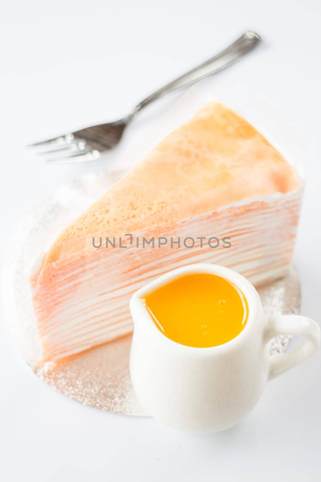 Orange whipped cream crepe cake on white background, stock photo