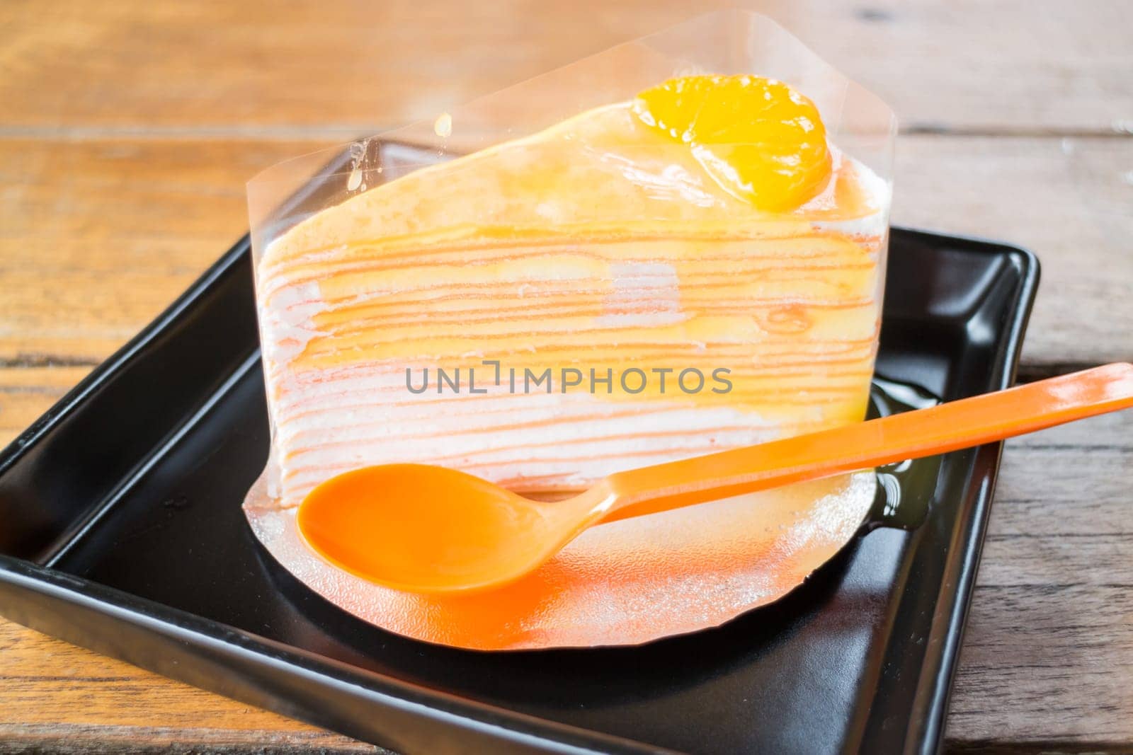 Delicious fresh orange crepe cake with sauce, stock photo