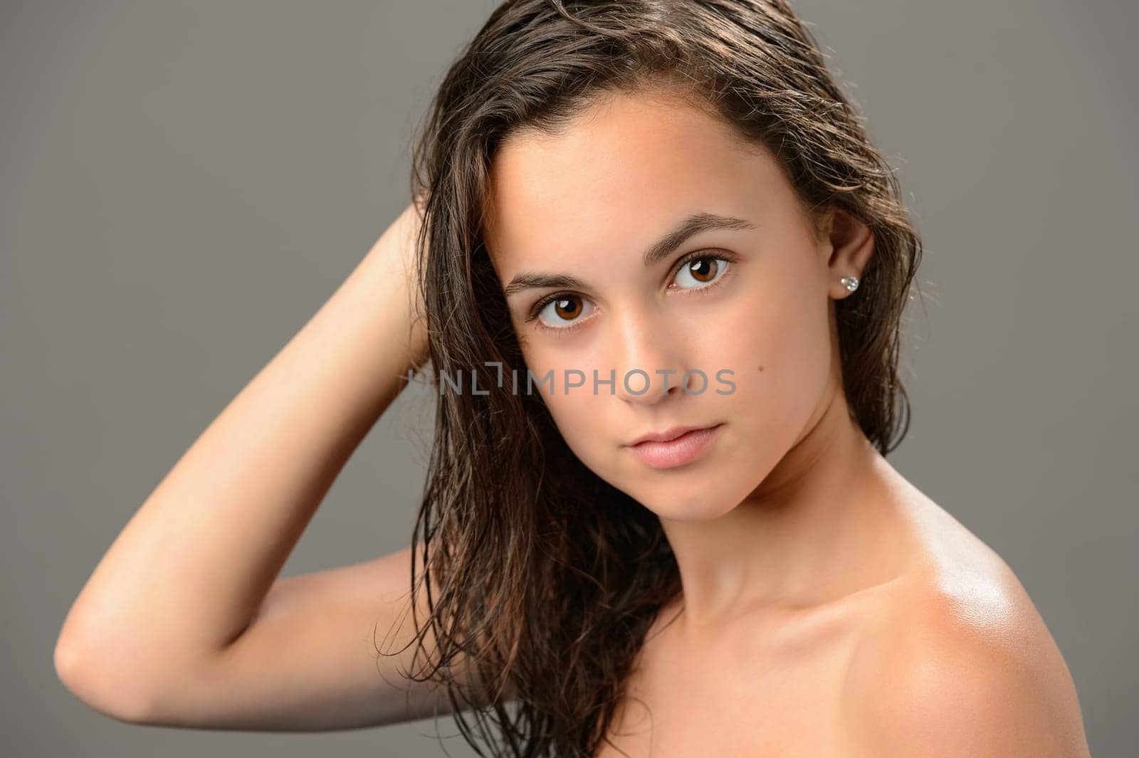 Teenage girl brunette wet hair beauty skin on gray background
