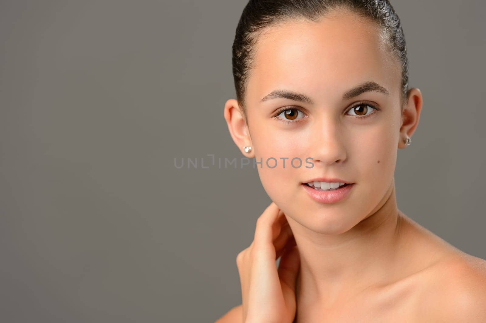 Teenage girl face cosmetics skin care close-up on gray background