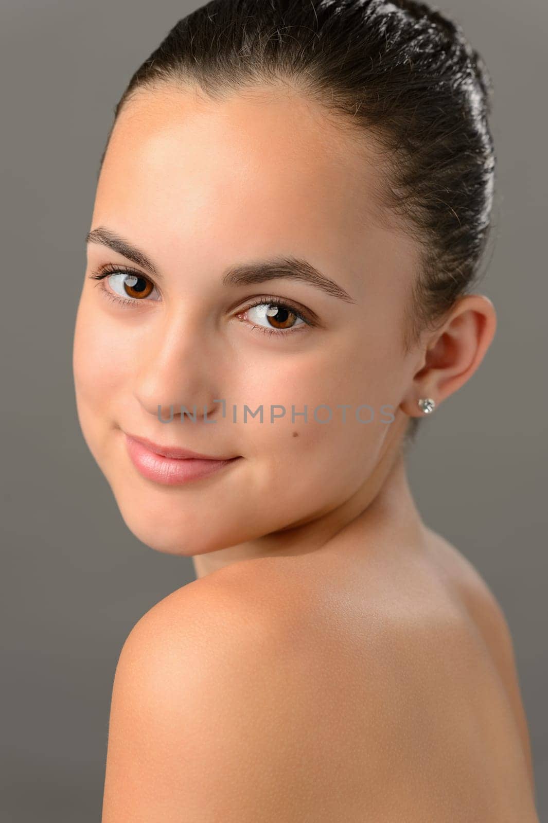 Teenage girl bare shoulders skin beauty face portrait on gray