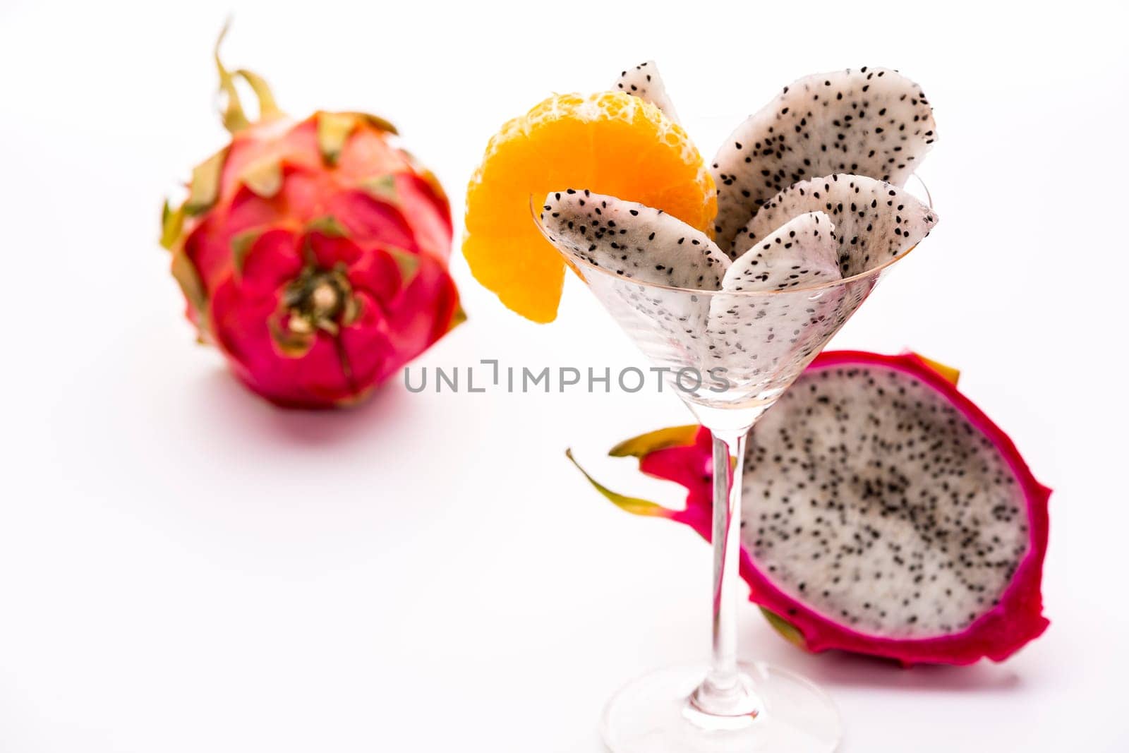 Wedges of the dragon fruit assorted in a long-stemmed glass and decorated with a mandarine slice,which also corresponds as regards taste..