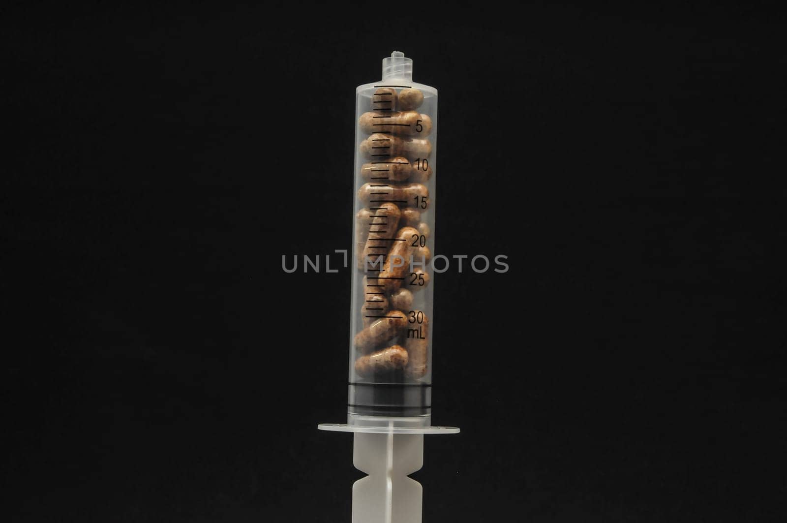 Medical Syringe Full of Pill Drugs on a Black Background