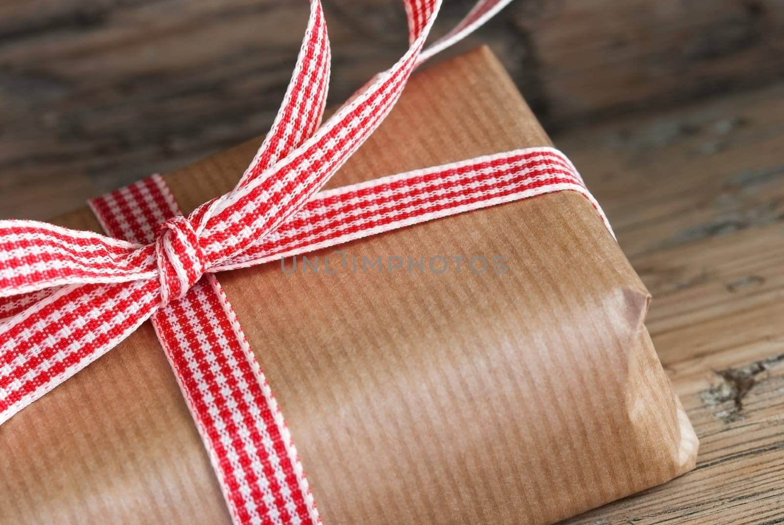 Closeup of a Rustic Present, Gift Wrapped with Red White Ribbon