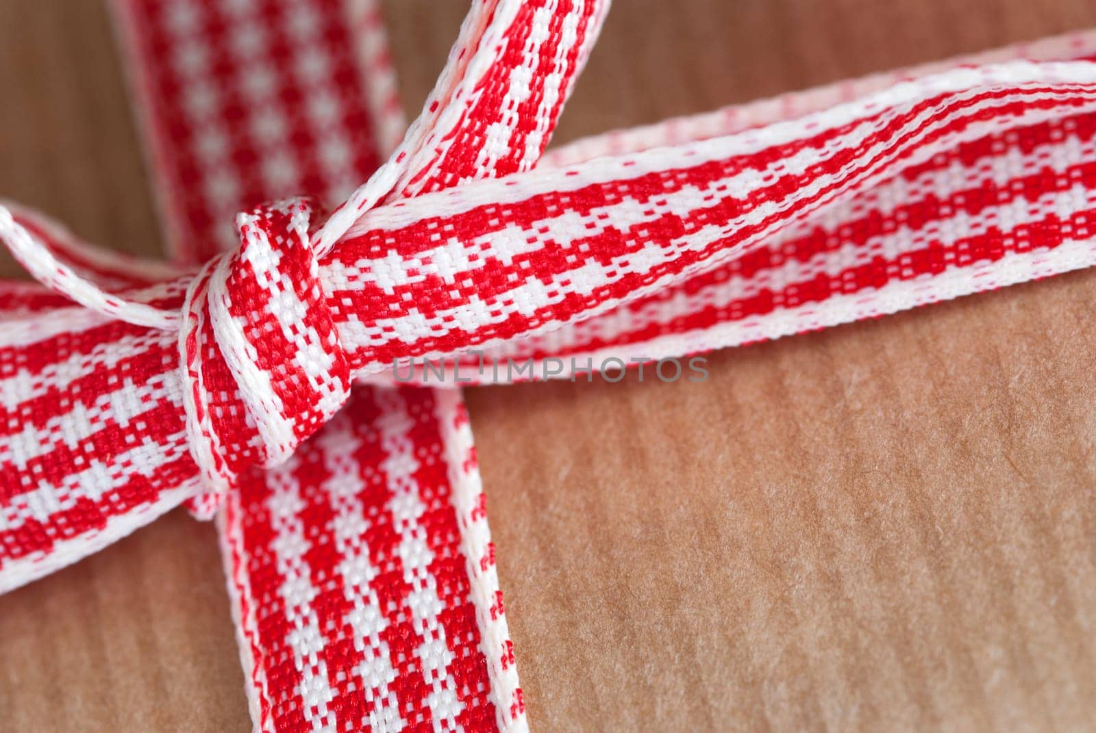 Present Ribbon Closeup in Red White on a Brown Background