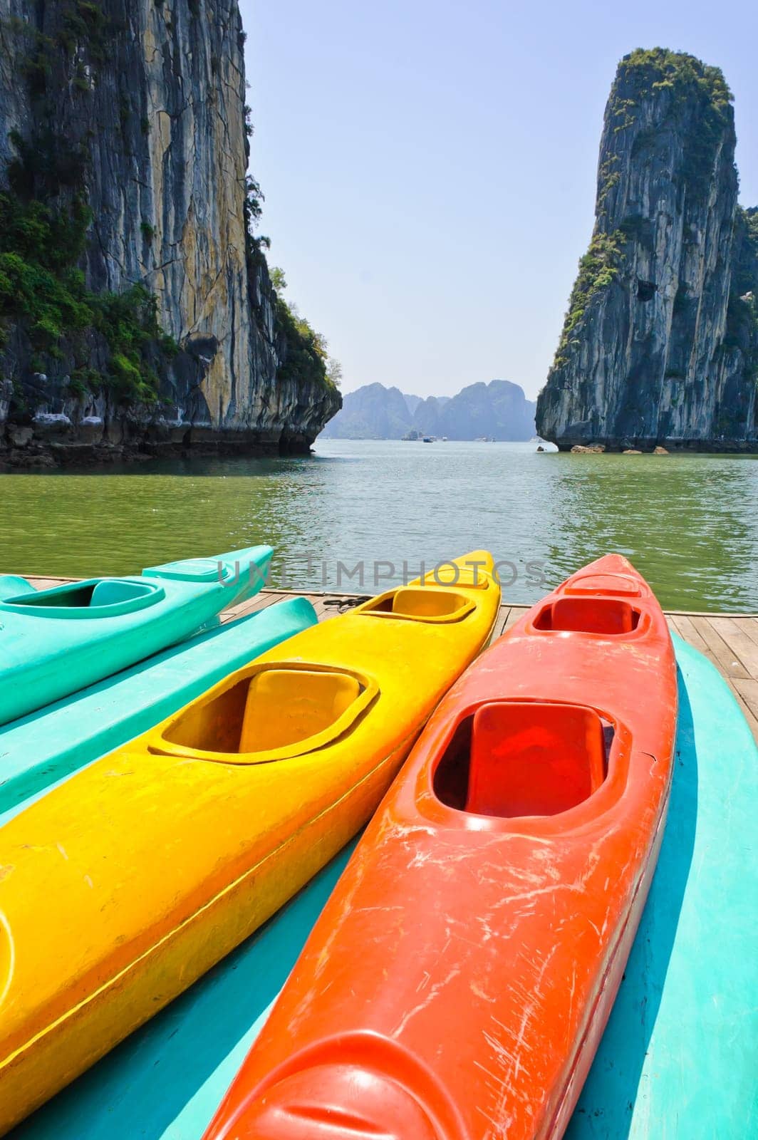 Colourful kayaks with limestone mountains background at Halong bay, Vietnam