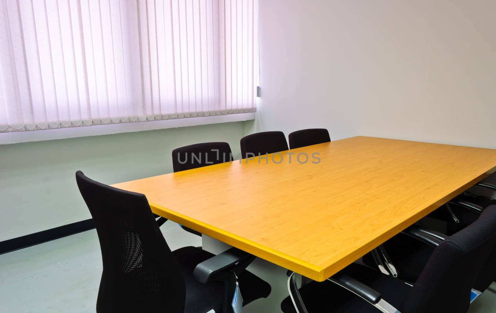 Small meeting room with wooden table and black chairs