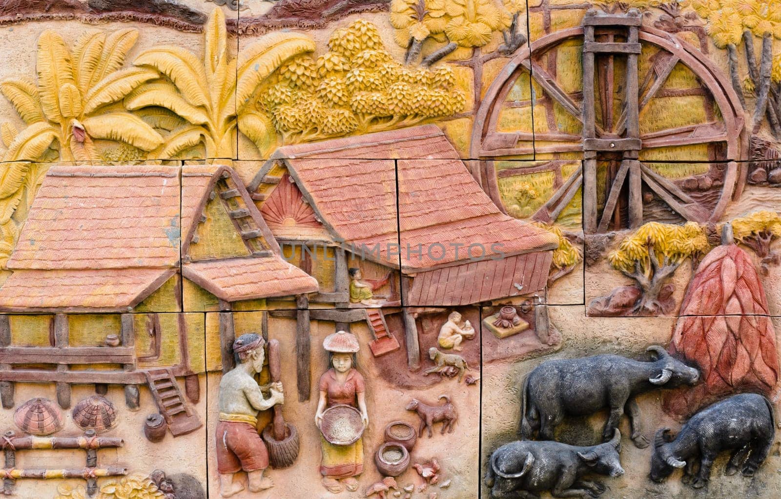 Stone carving of traditional Thai rural culture on temple wall