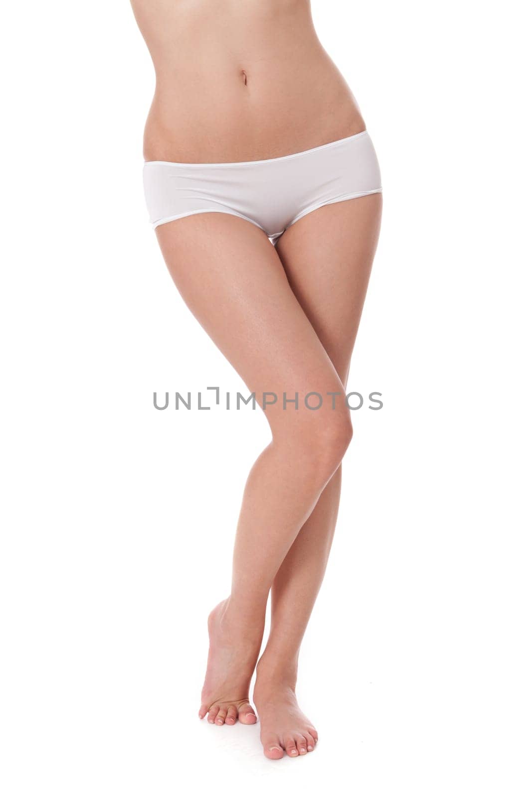Bodypart cutout of a young woman from waist to feet with white underwear isolated on white background