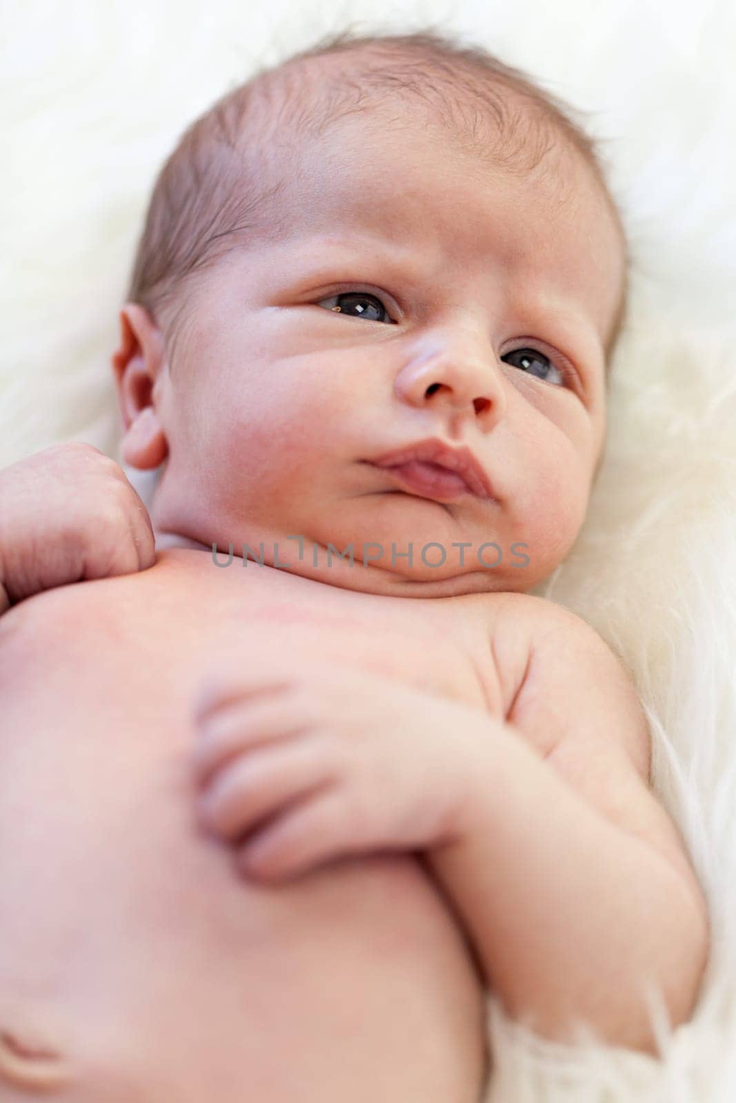 Little baby toddler newborn naked on a white fur as Detal