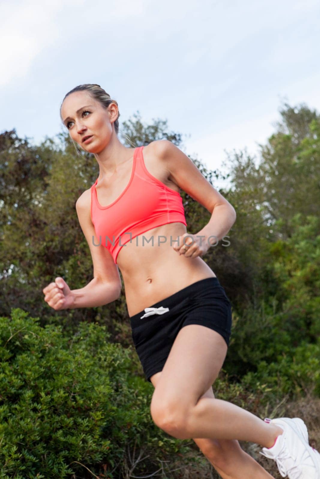 attractive sporty young woman jogging on an outdoor street in daylight