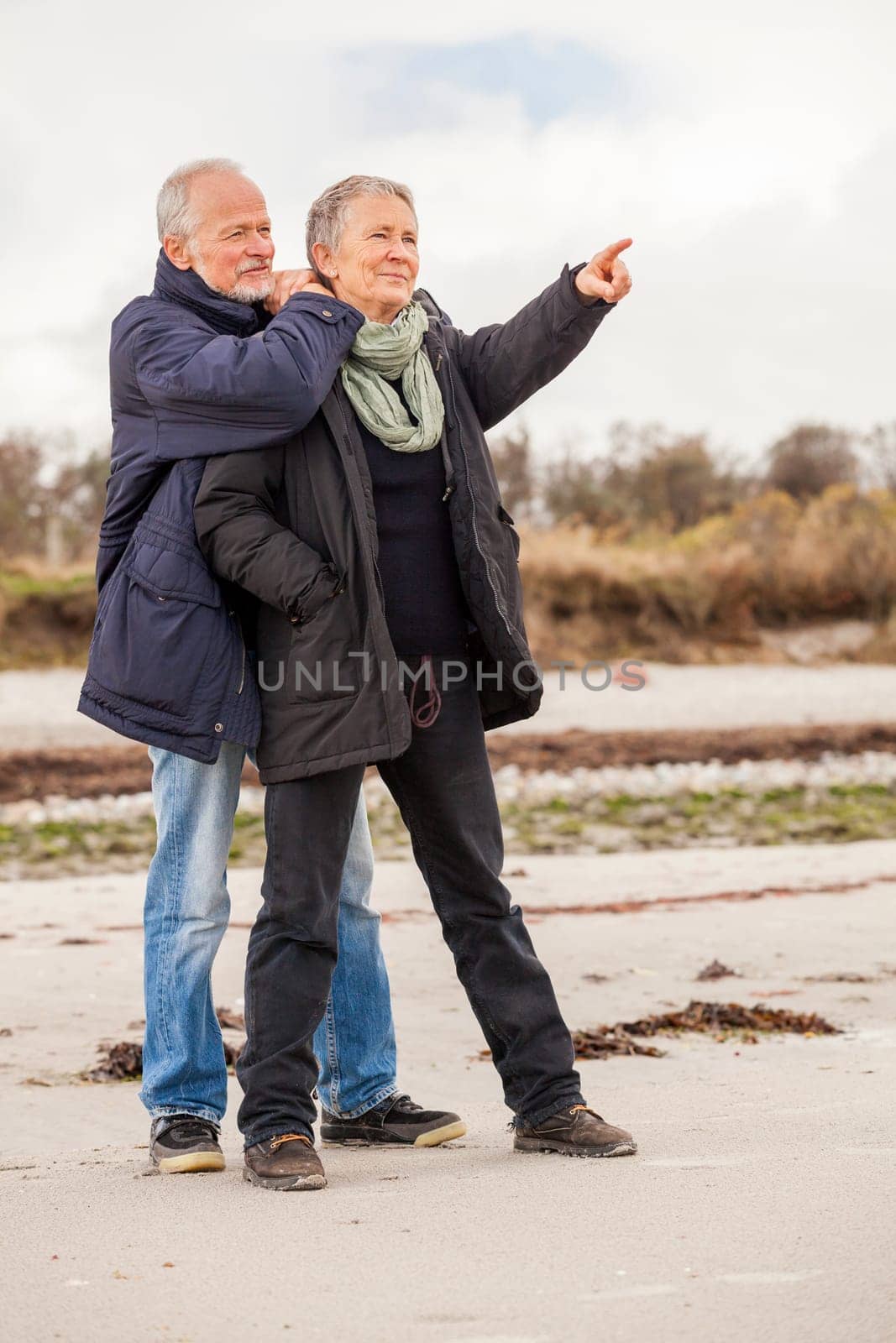 older adult happy couple walks on the beach in autumn lifestyle happiness