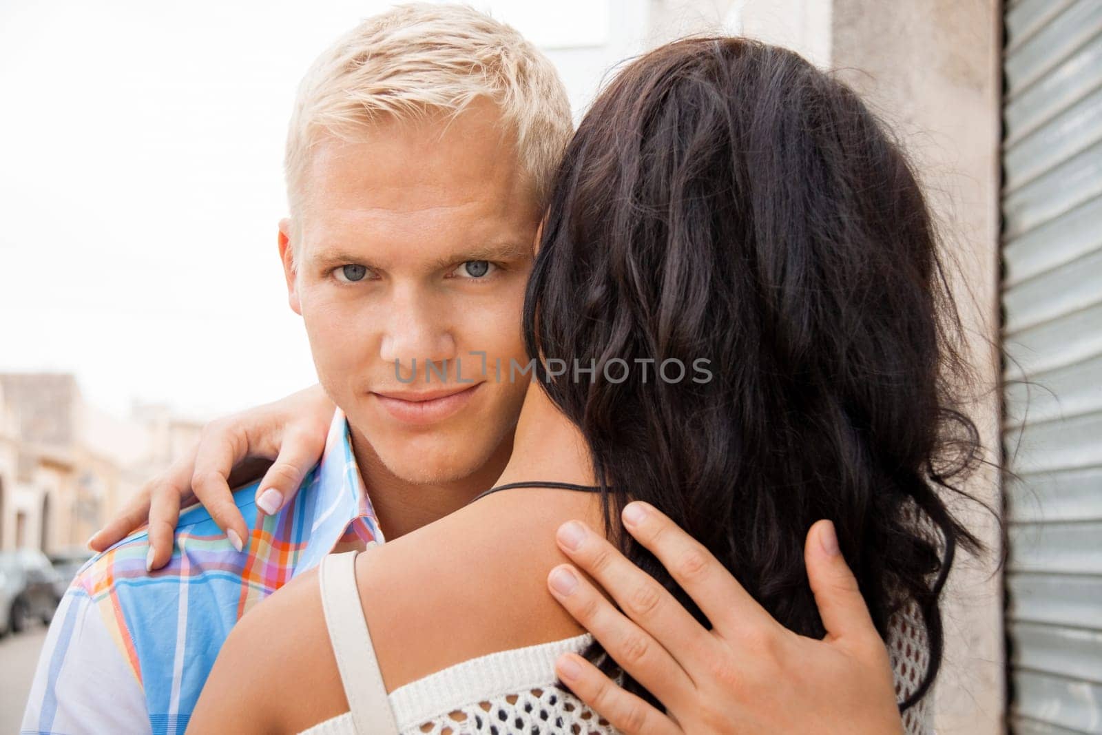 Blonde young man hugs his girlfriend portrait close-up people couple