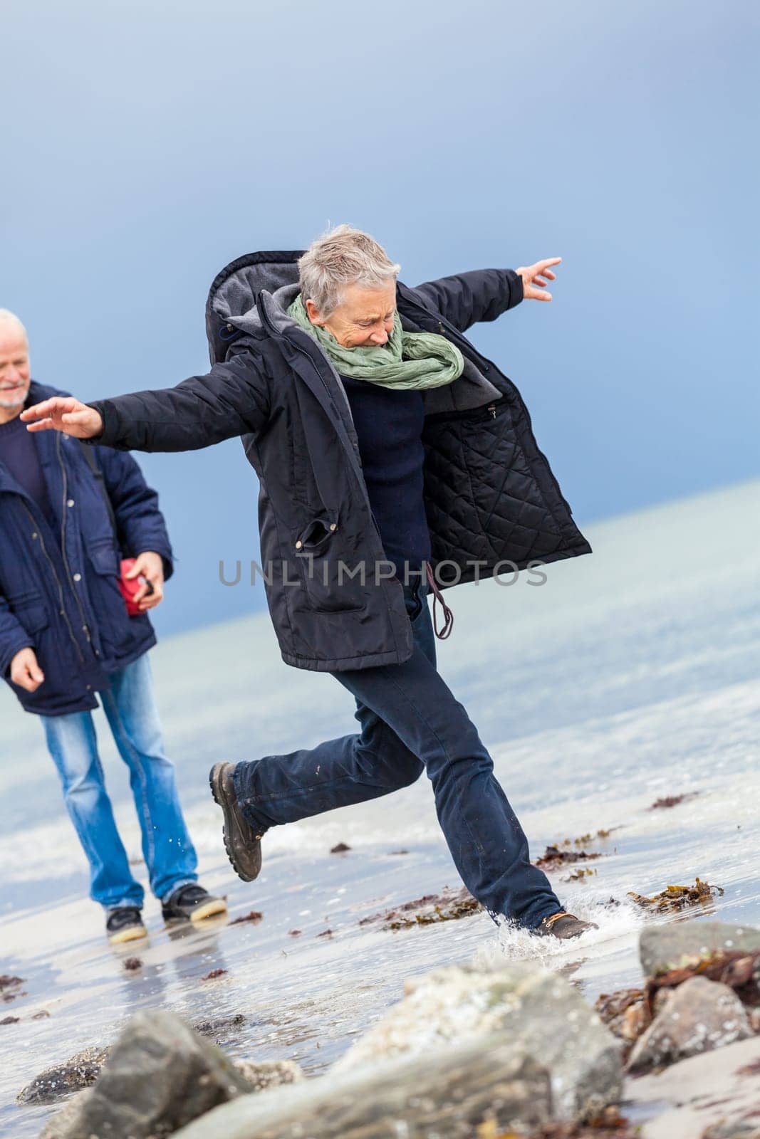 older adult happy couple walks on the beach in autumn lifestyle happiness