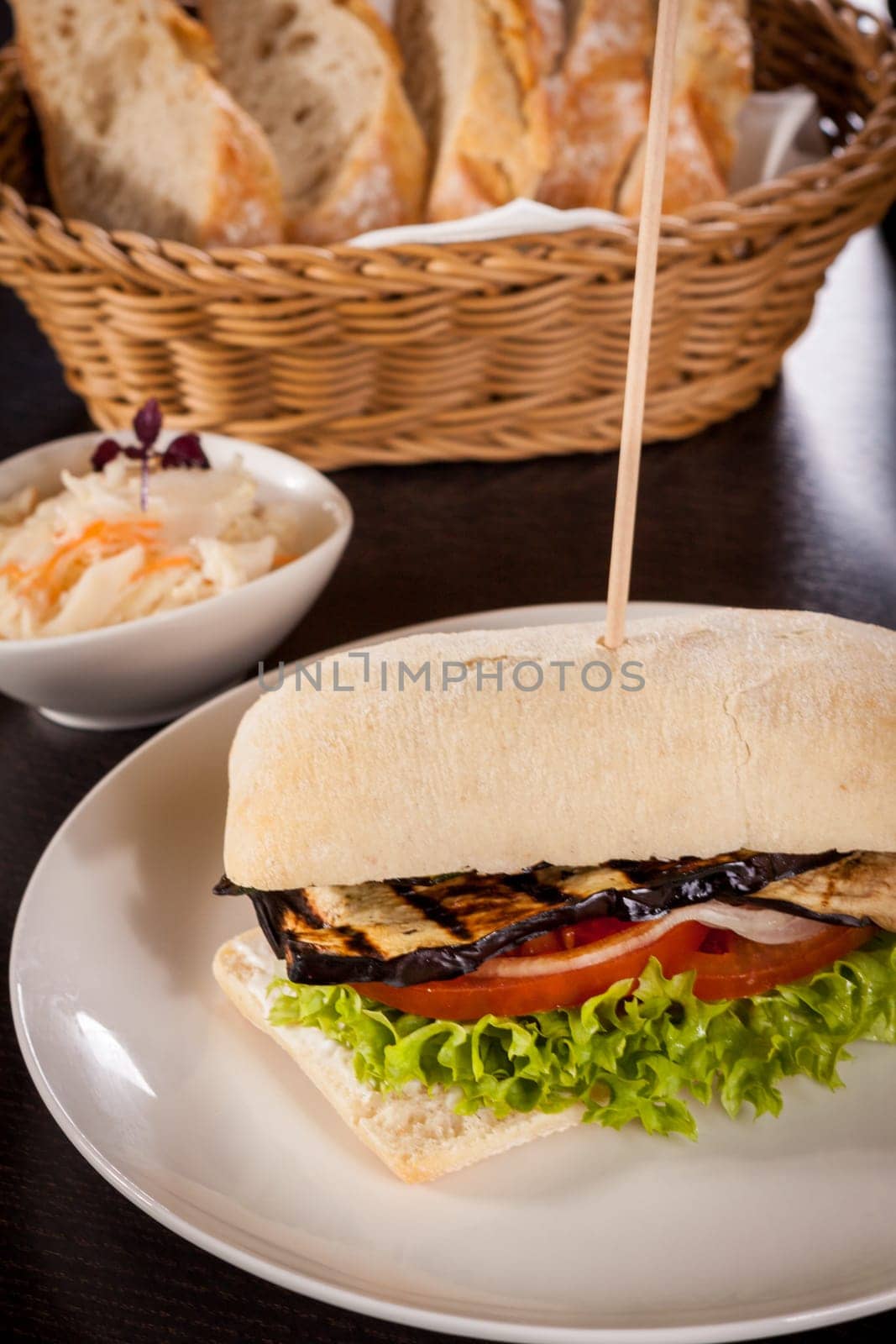Vegetarian vegan hamburger with aubergine tomato and salad in a ciabatta bun