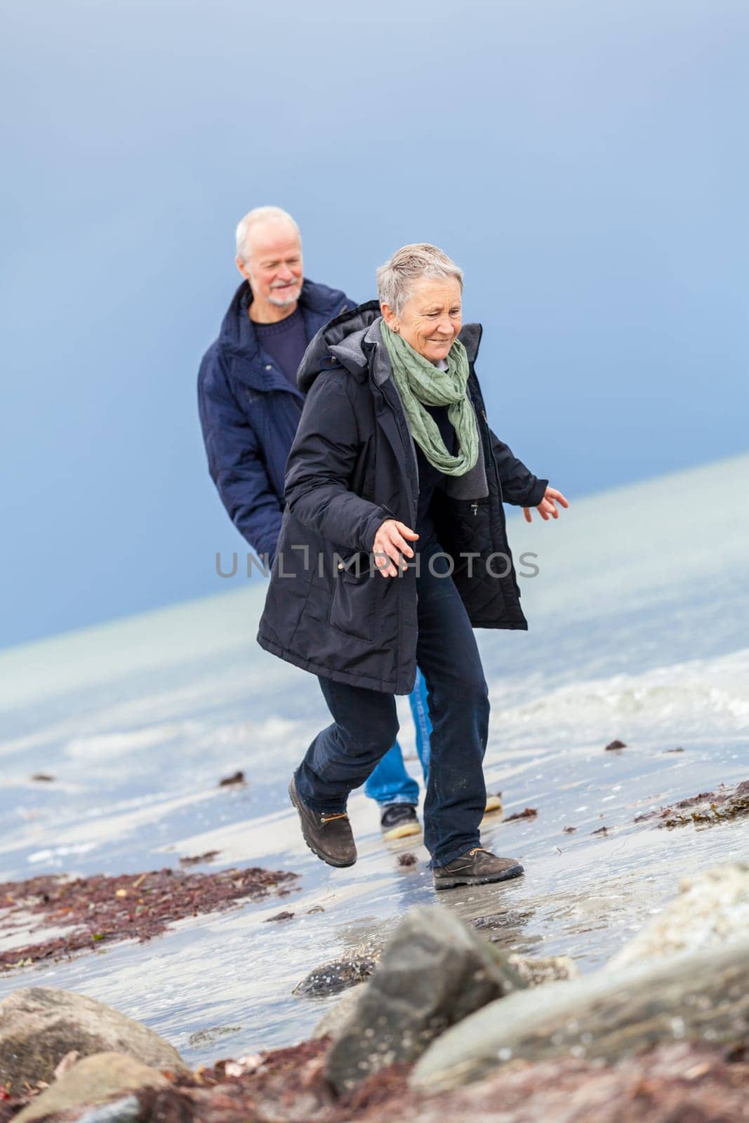 older adult happy couple walks on the beach in autumn lifestyle happiness