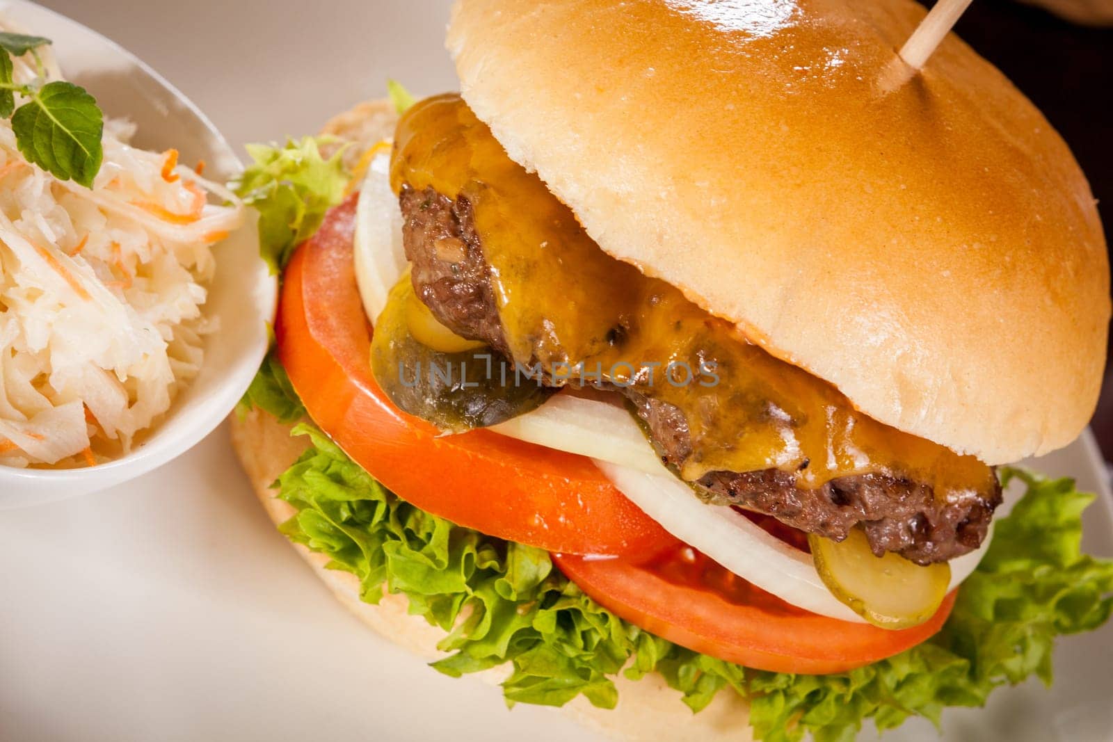 Delicious hamburger cheeseburger with bacon egg and salad on a plate