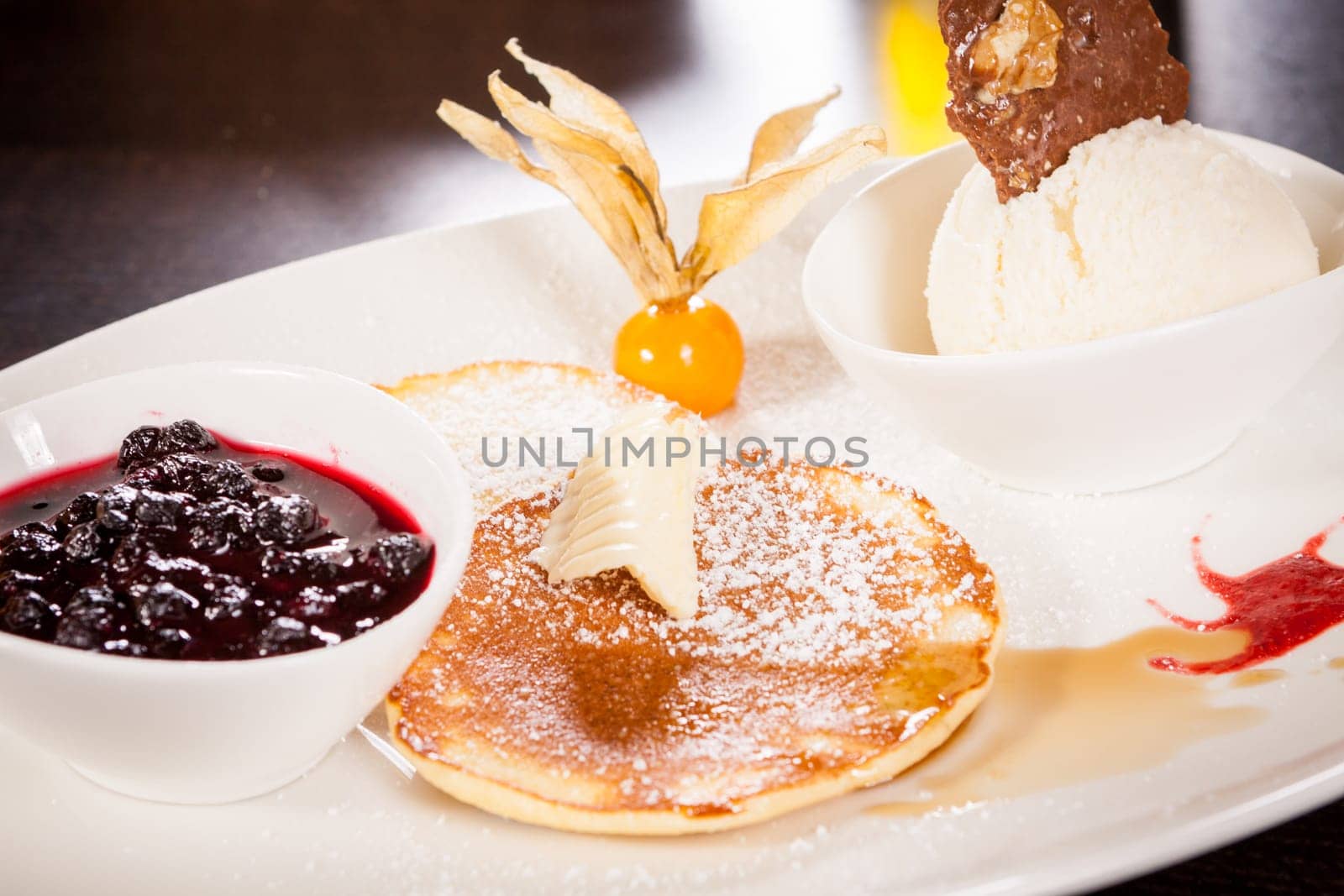 Delicious sweet pancakes as desser with vanilla ice cream prepared on a white plate