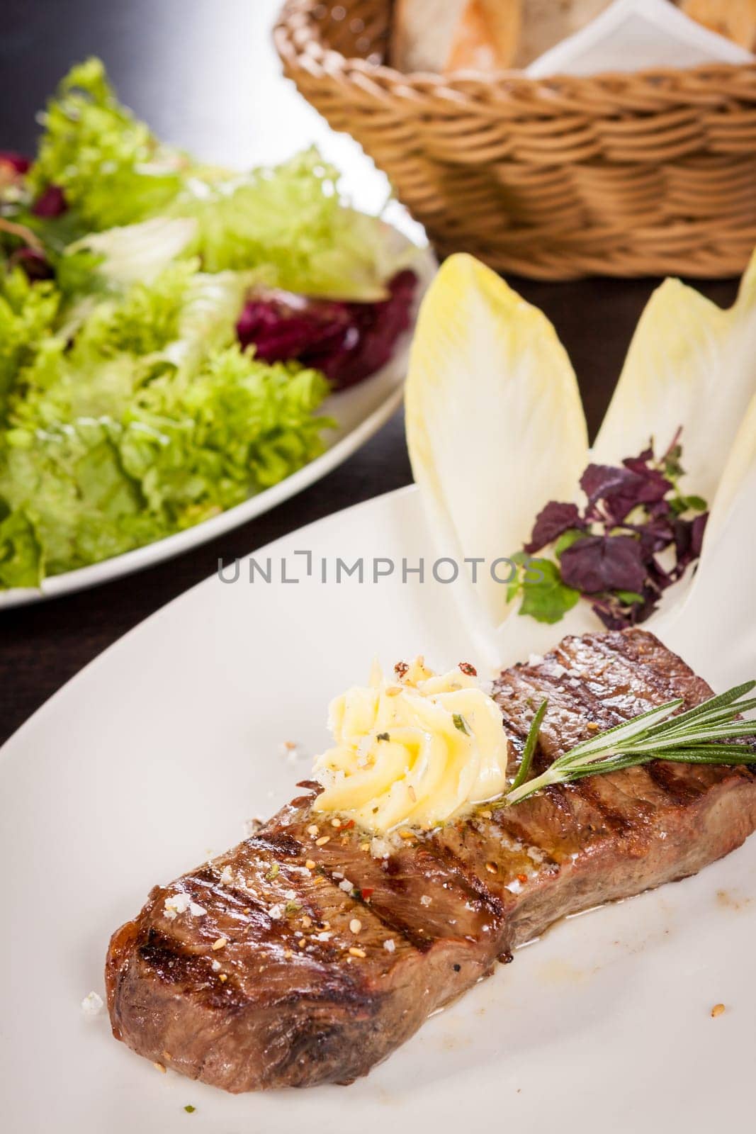 Succulent grilled beef fillet steak with homemade herb butter on a plate